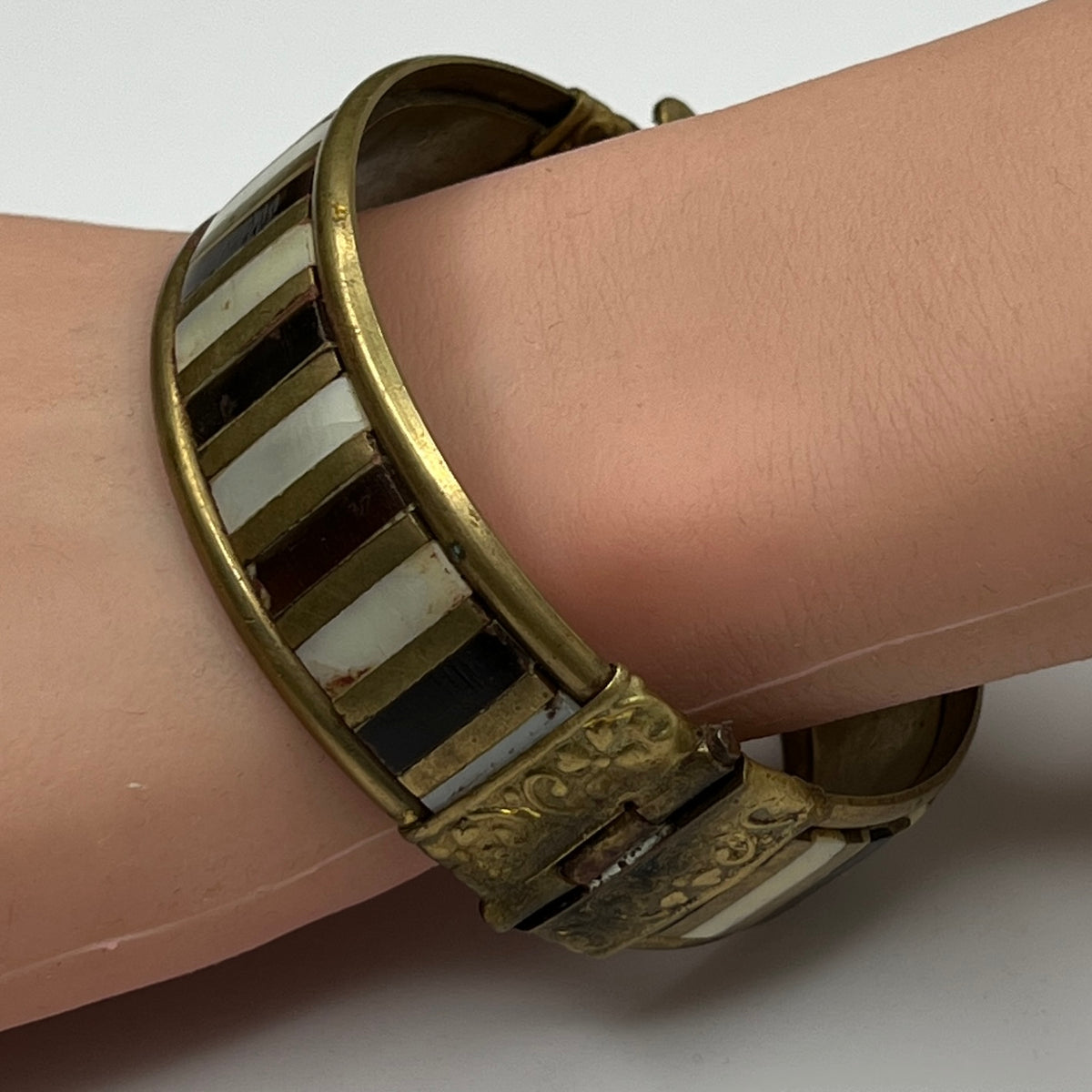 Rustic brass and mother of pearl artisan bangle worn on mannequin