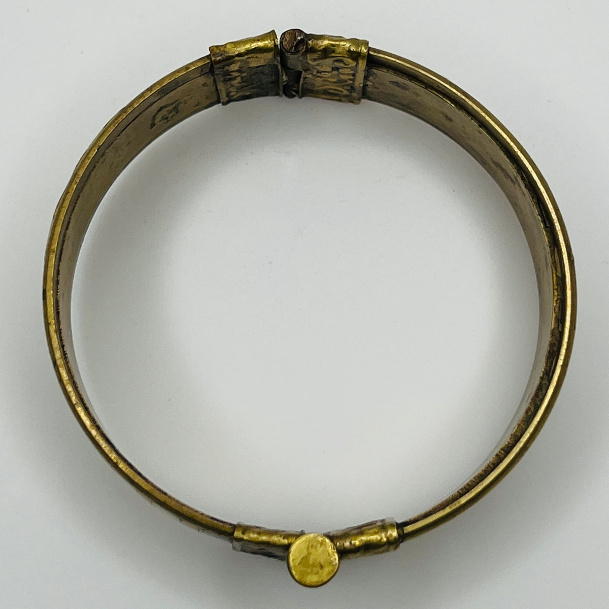 Vintage bangle with pin closure and etched end caps, close-up view