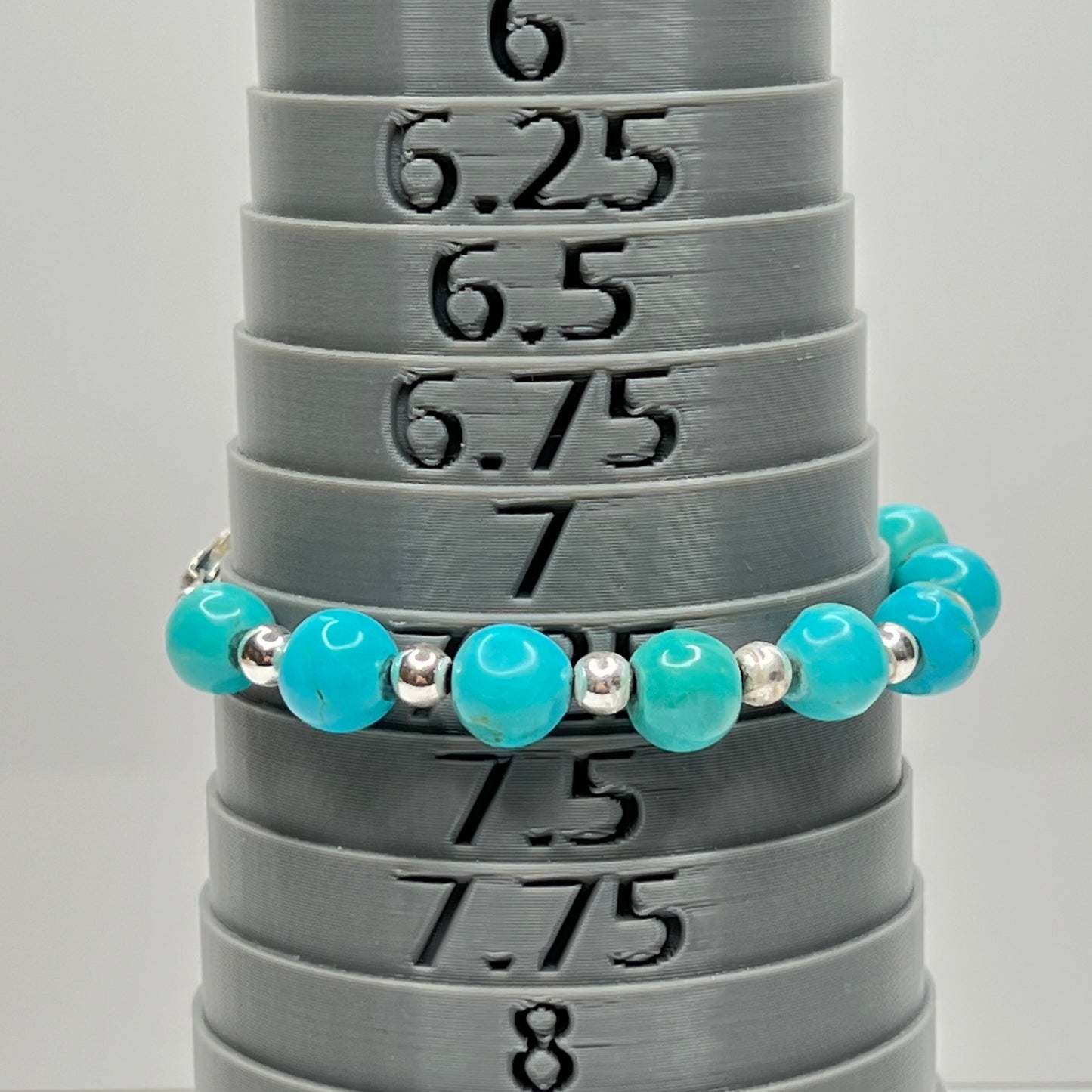 Turquoise and silver beaded bracelet on bracelet mandrel