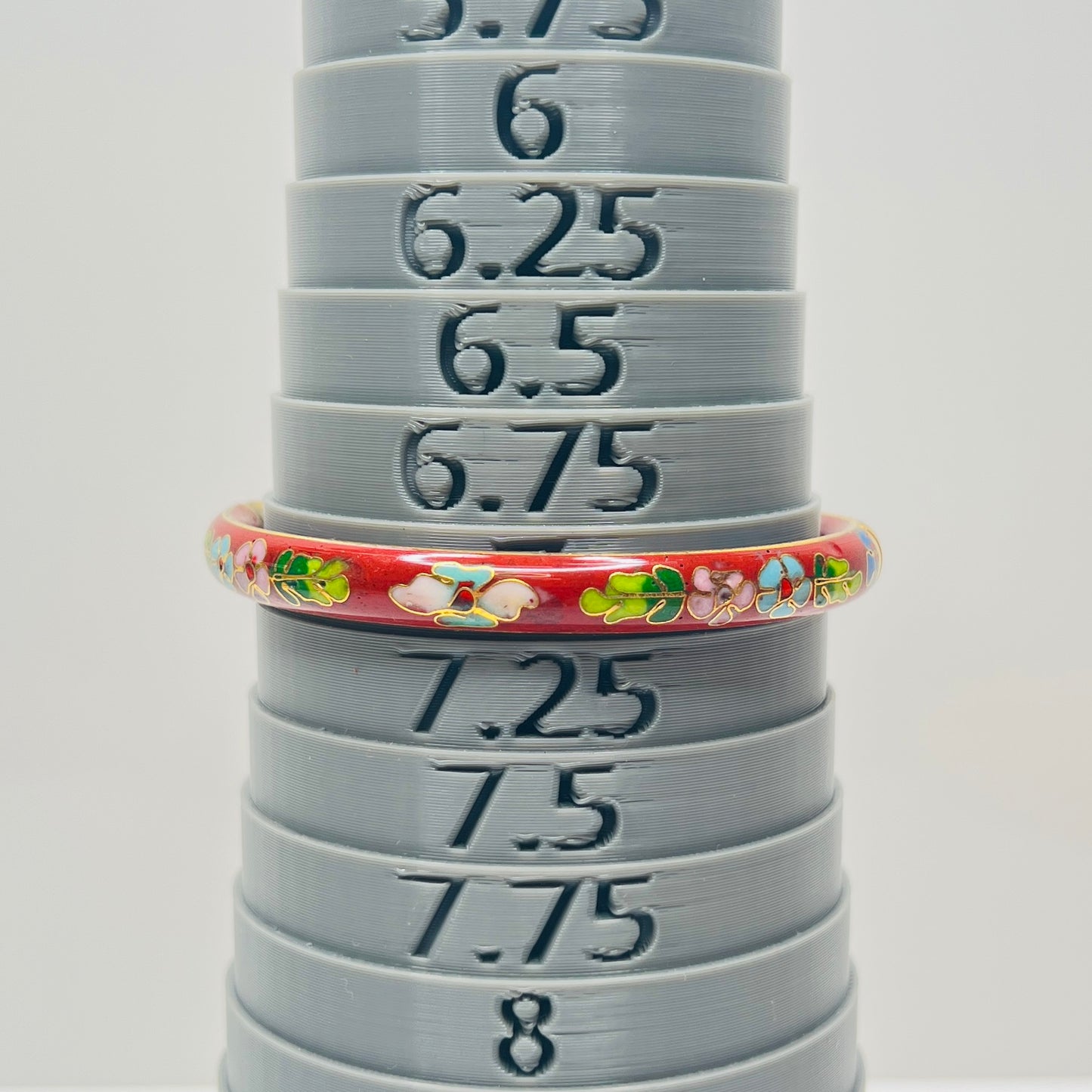 Close-up of enamel flower motifs on red background