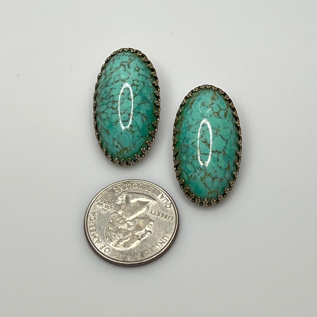 Clip-on earrings with crackled turquoise-style cabochons in silver setting