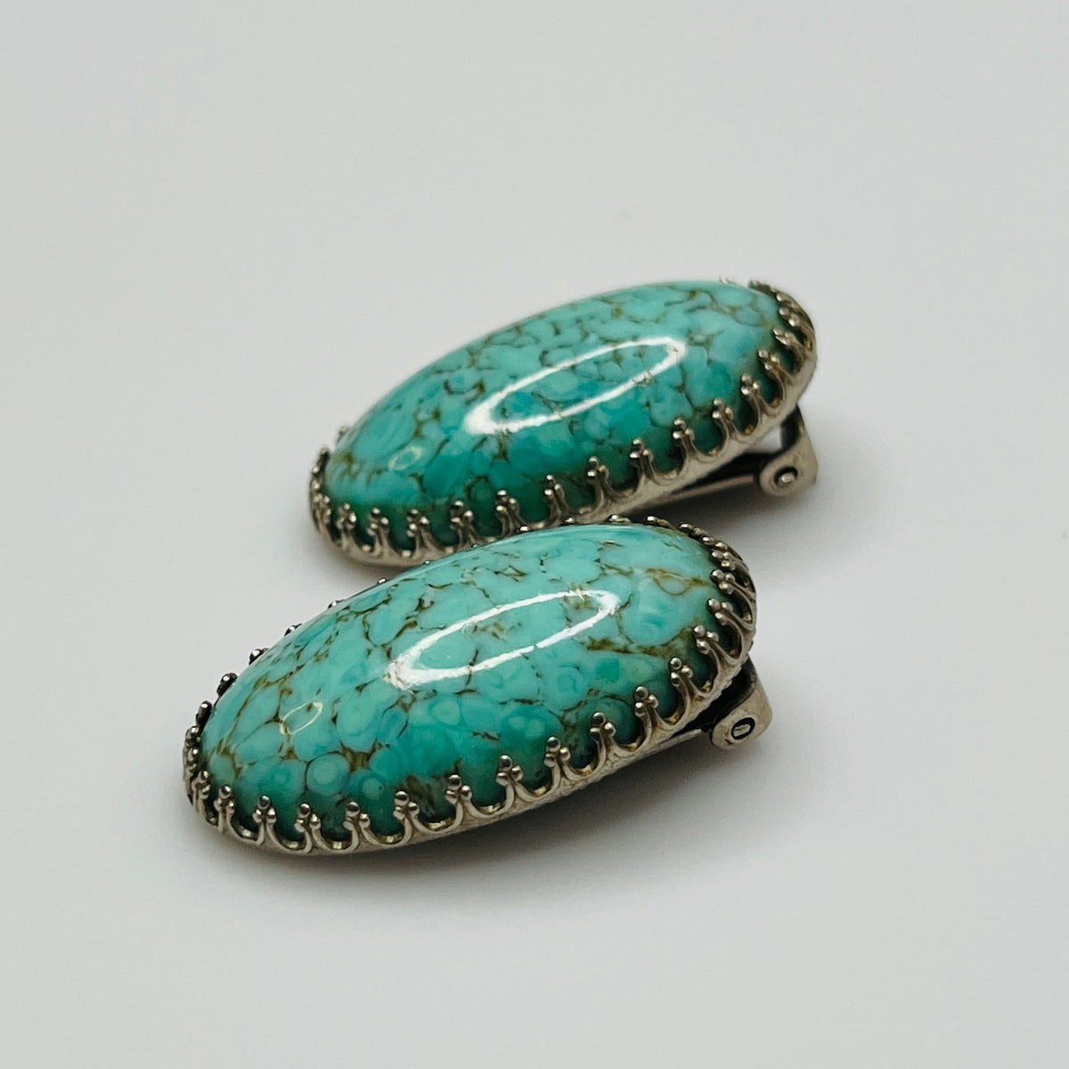 Clip-on earrings with crackled turquoise-style cabochons in silver setting