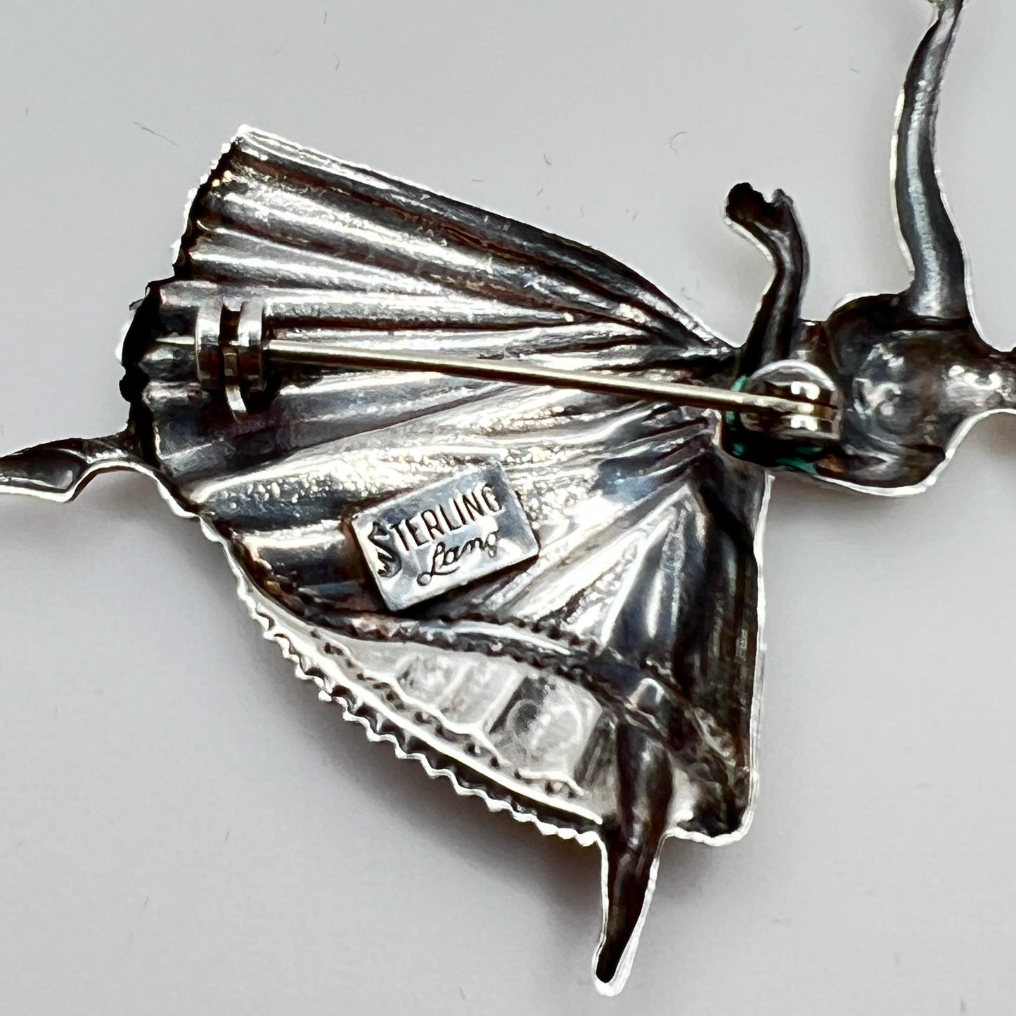 Back view showing “STERLING Lang” maker’s mark and pin clasp