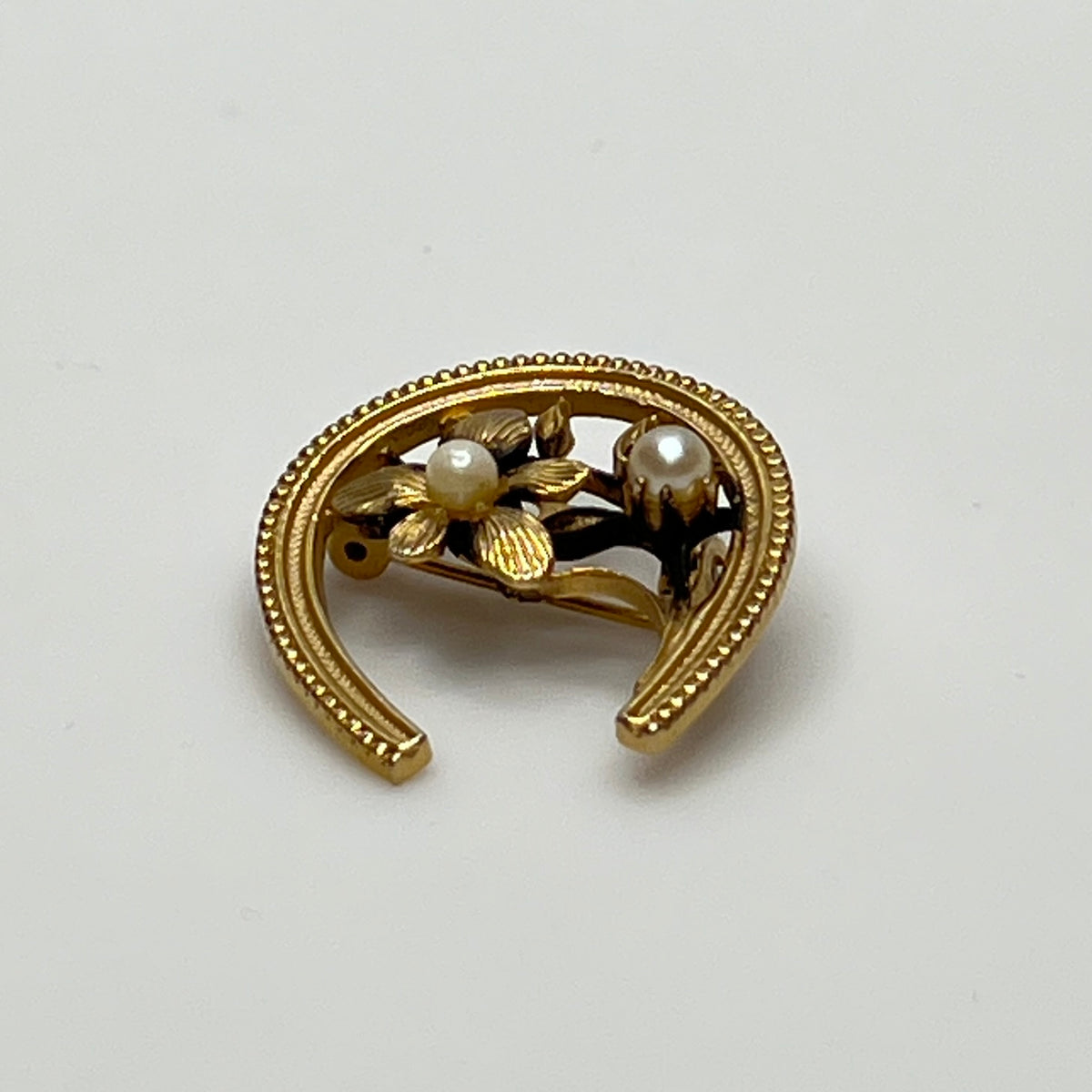 Vintage gold horseshoe brooch with flower and pearl detail