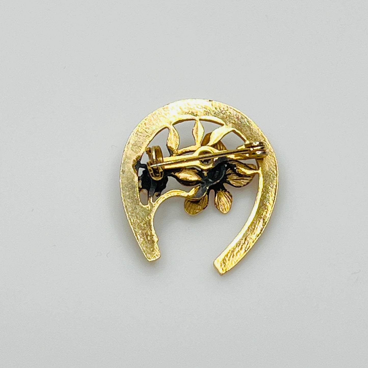 Back view of gold-tone horseshoe pin