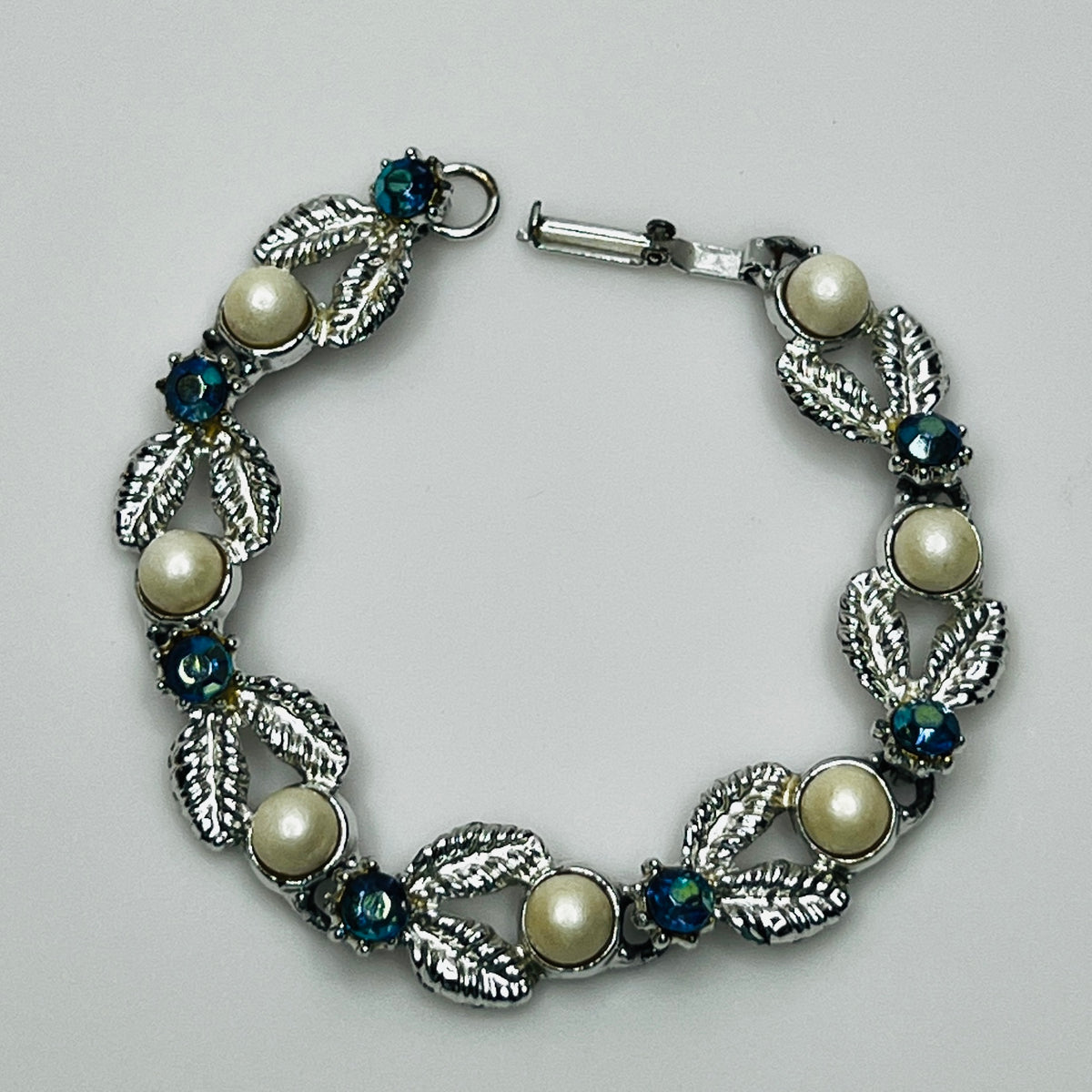 Close-up of vintage silver bracelet with aurora borealis stones and pearl details