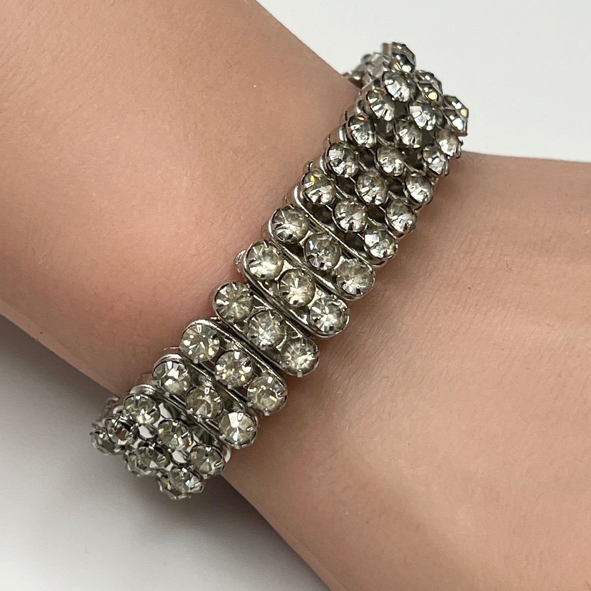 Close-up of vintage silver-tone accordion rhinestone bracelet on wrist