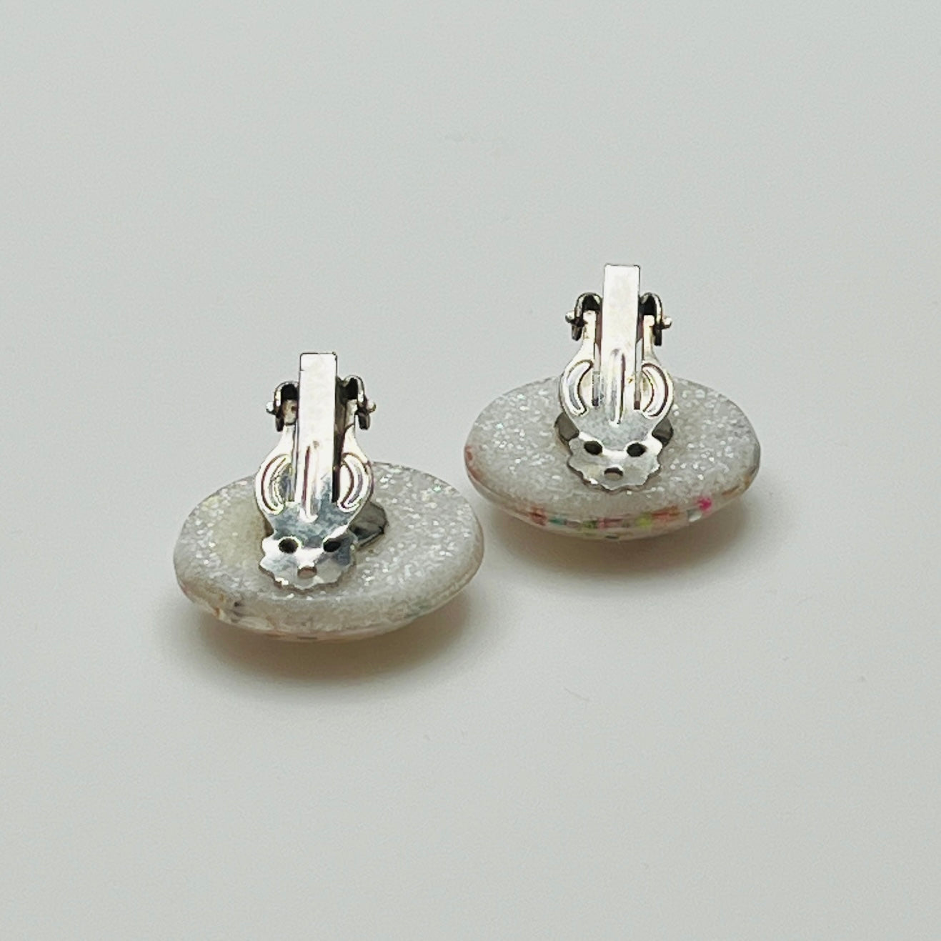 Mid-century plastic earrings with suspended confetti sparkle