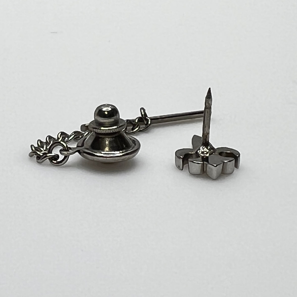 Vintage silver fleur-de-lis tie tack with chain and clutch backing.