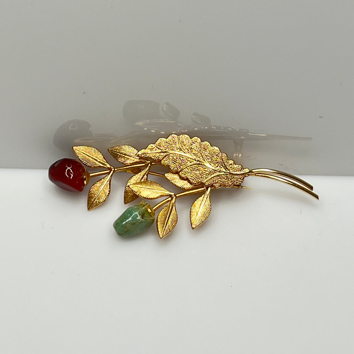 Vintage gold-tone brooch with red and green jade rose buds on long stem