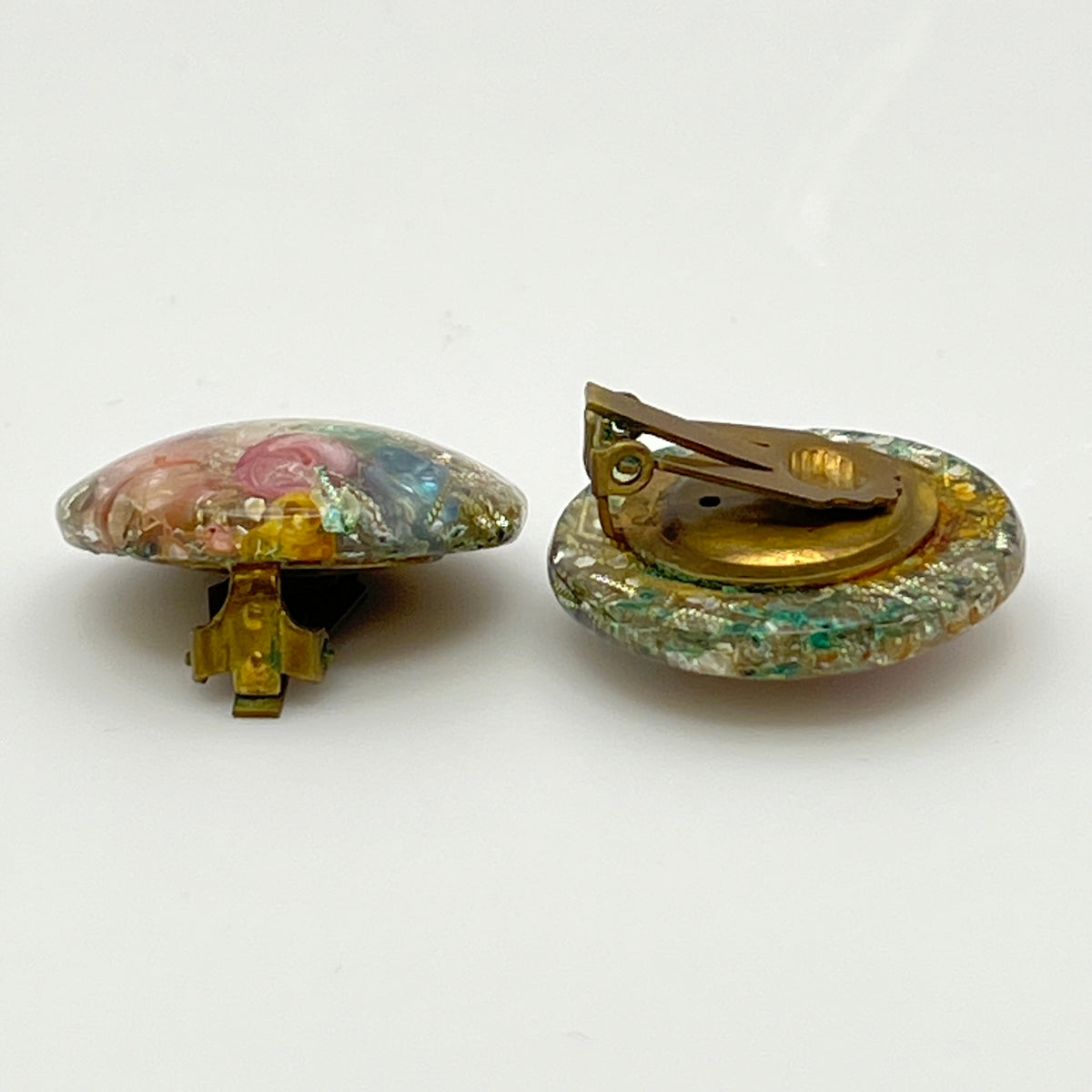 Close-up of lucite earrings with multicolor seashells and gold sparkle