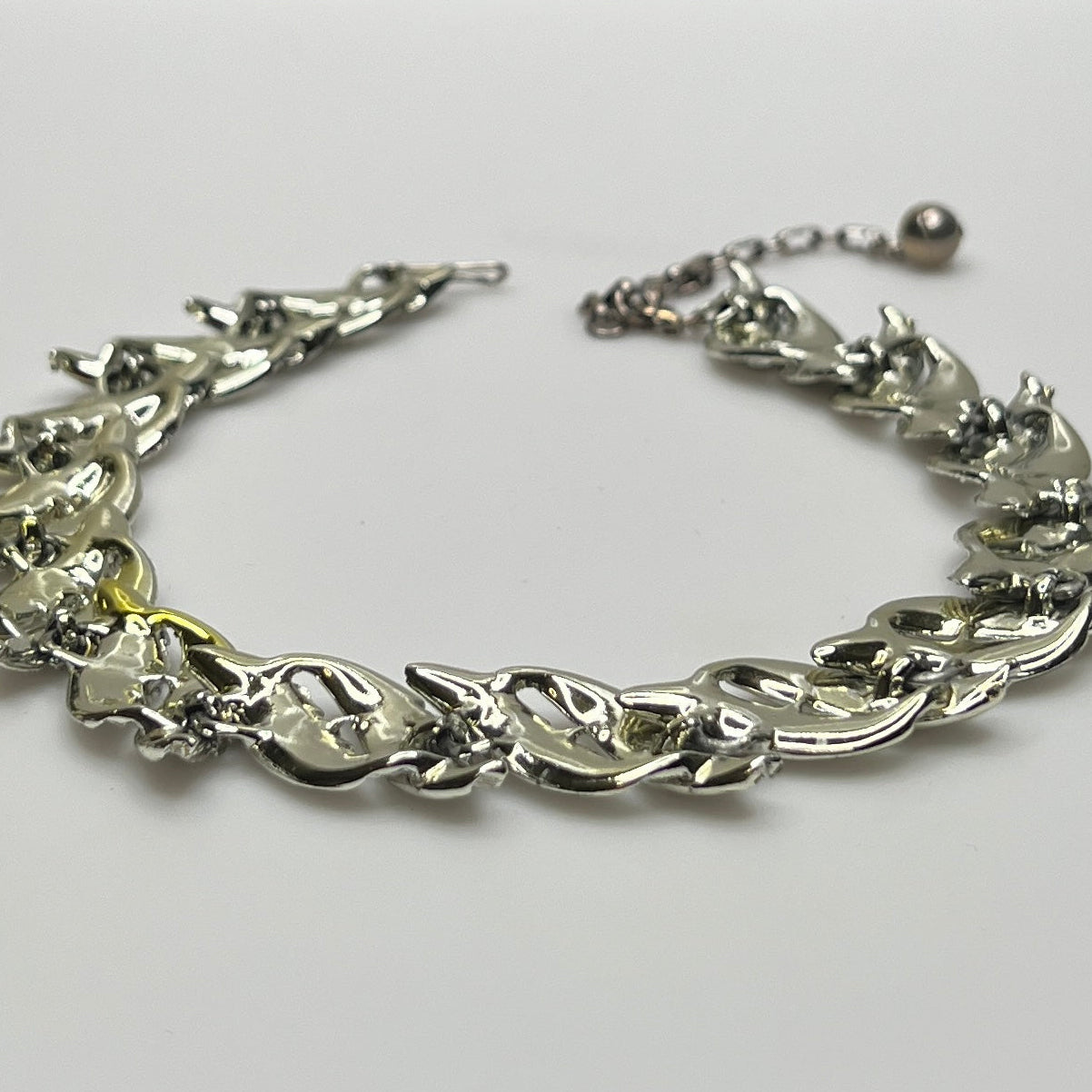 Mid-century silver-tone choker necklace with sculpted leaf links and hook extender clasp.