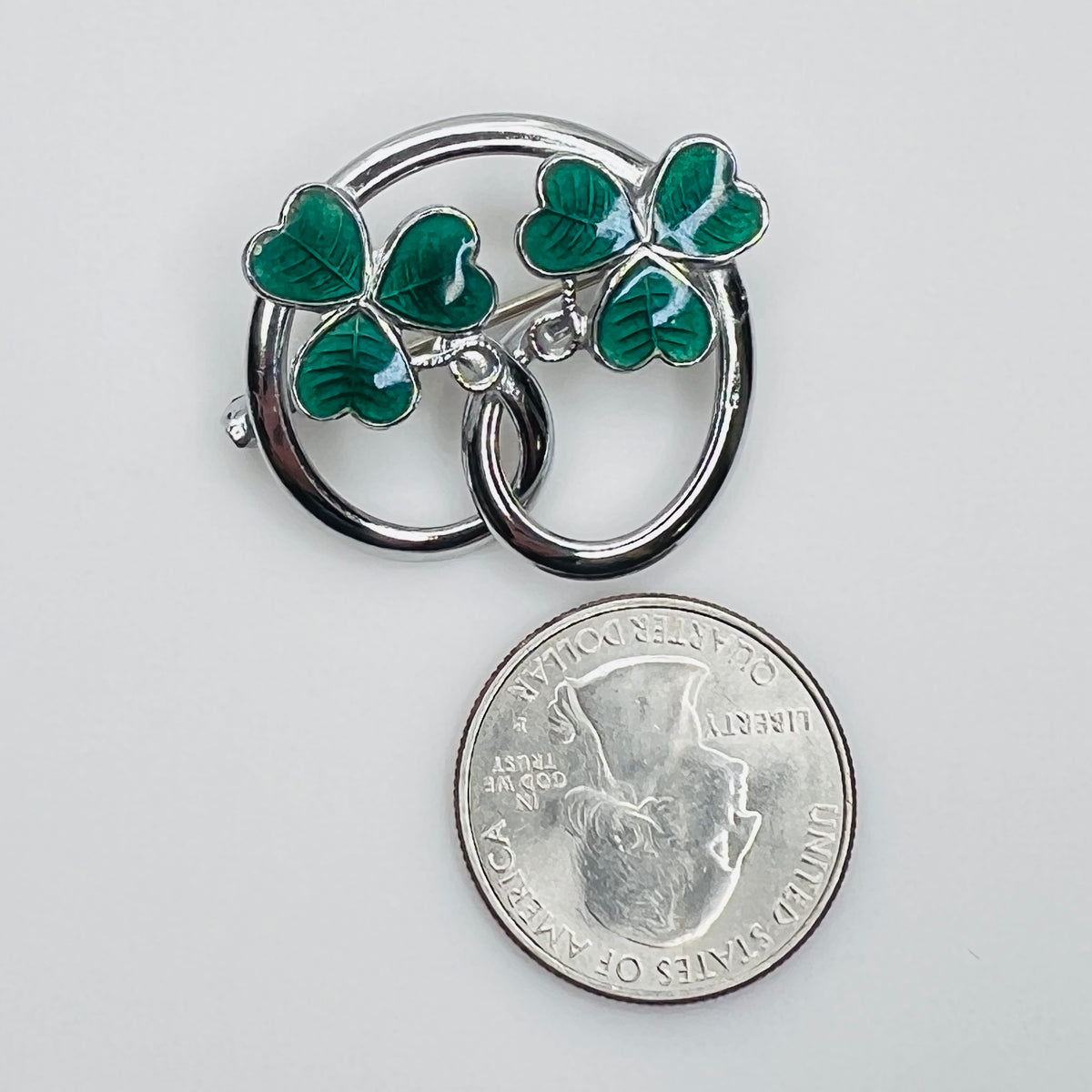 Silver tone double shamrock brooch with green enamel leaves