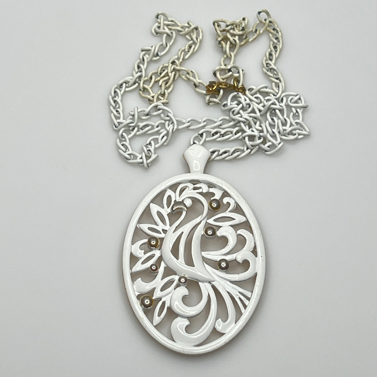Close-up of pendant and chain showing vintage wear on enamel near clasp