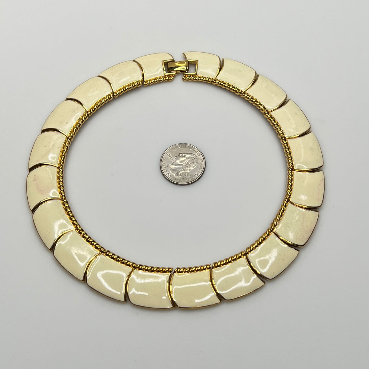 Close-up of enamel and gold tone links with rope detailing