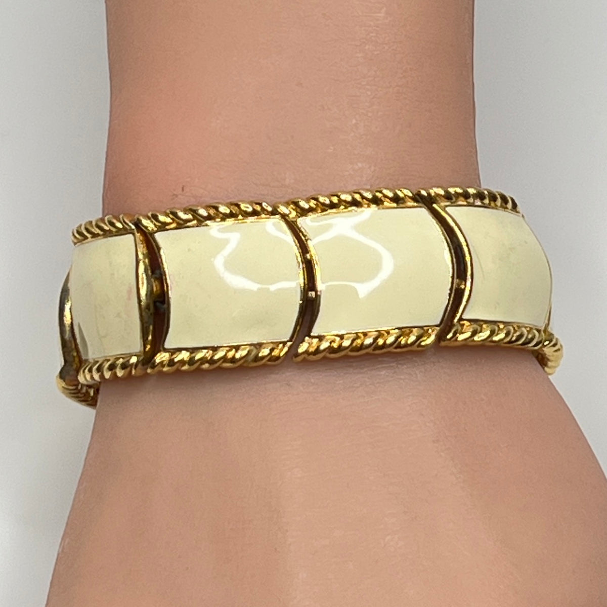 Close-up of enamel and gold tone links with rope detailing