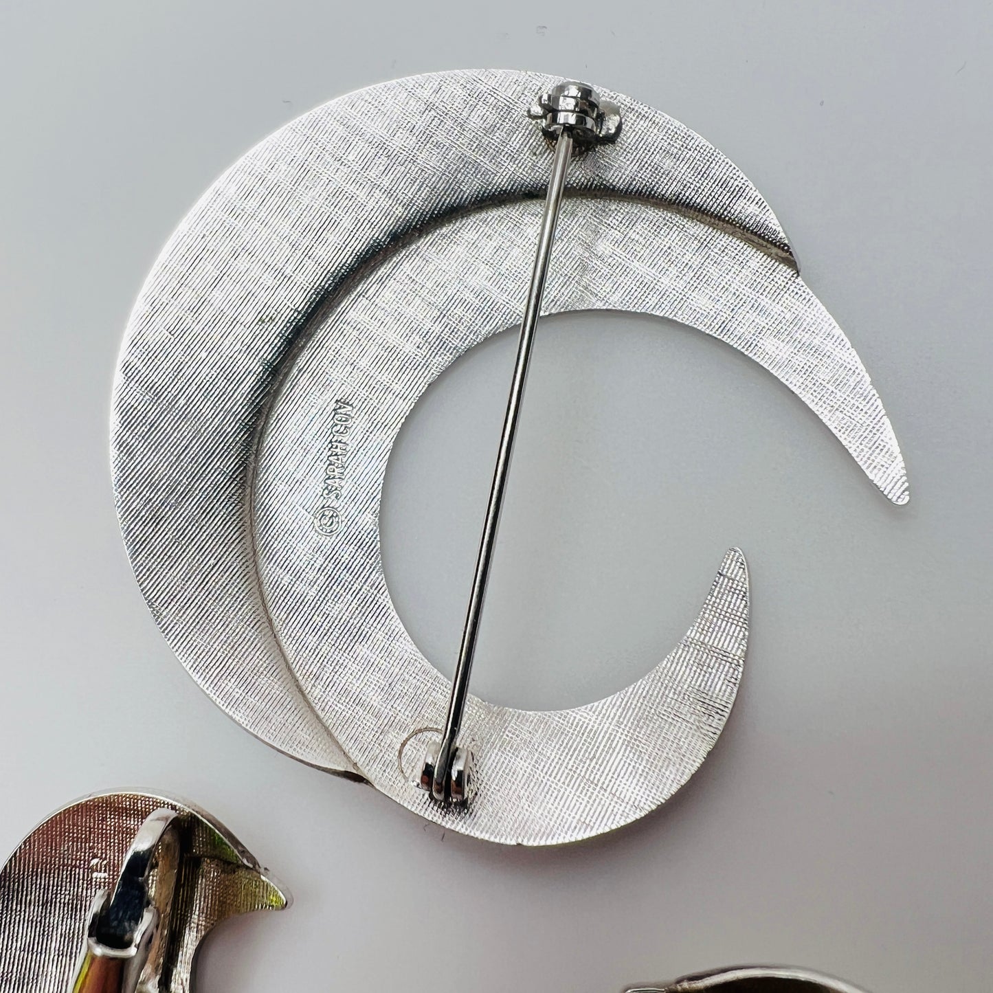Close-up of sculptural crescent moon shapes in shiny silver finish