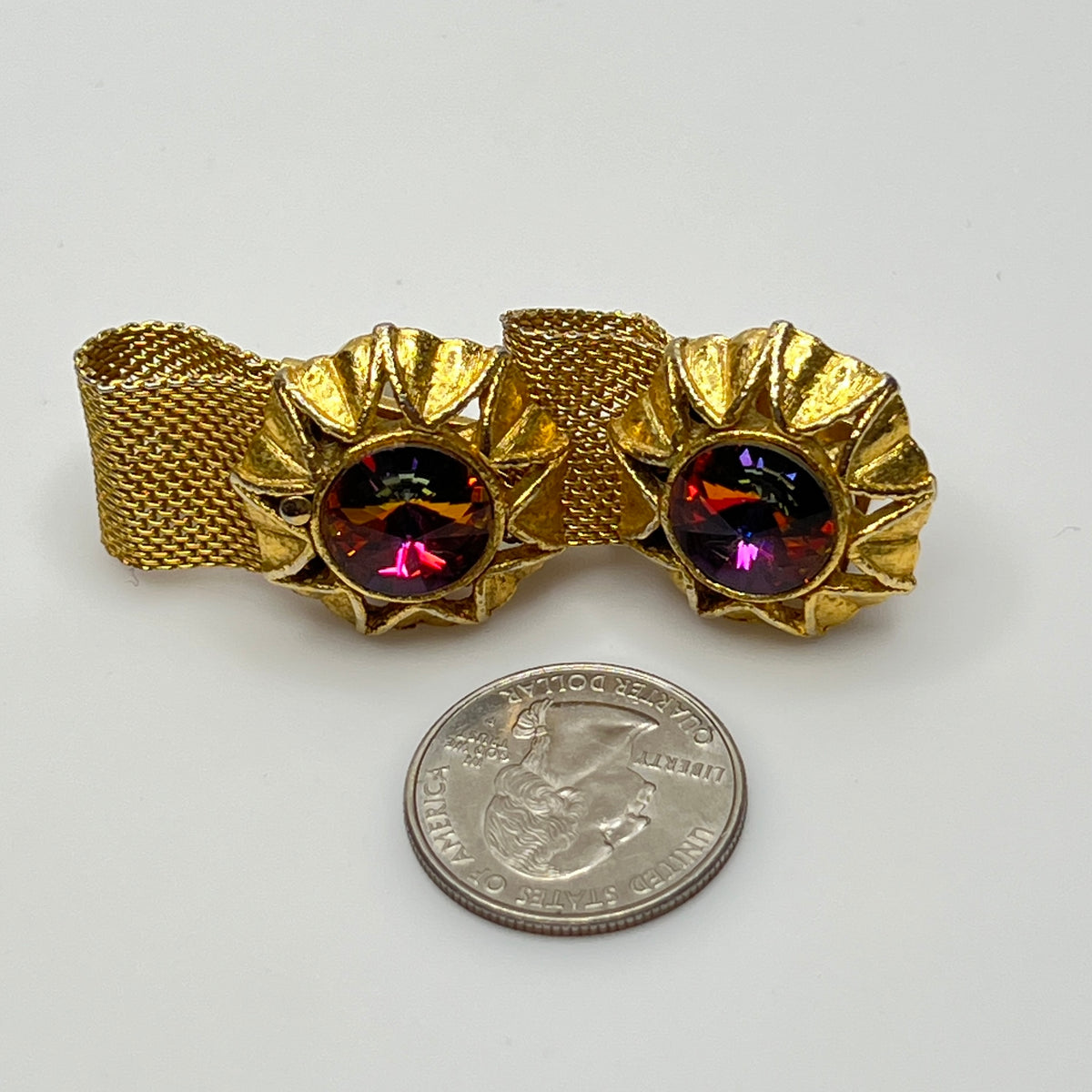 Close-up of round prismatic rivoli cufflink in gold-tone sunburst bezel