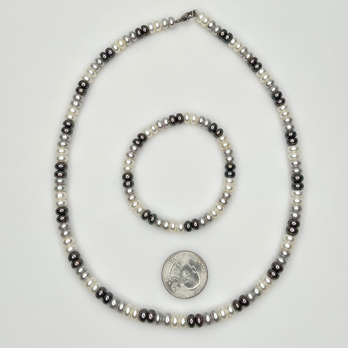 Close-up of matching pearl necklace and stretch bracelet in modern neutral tones