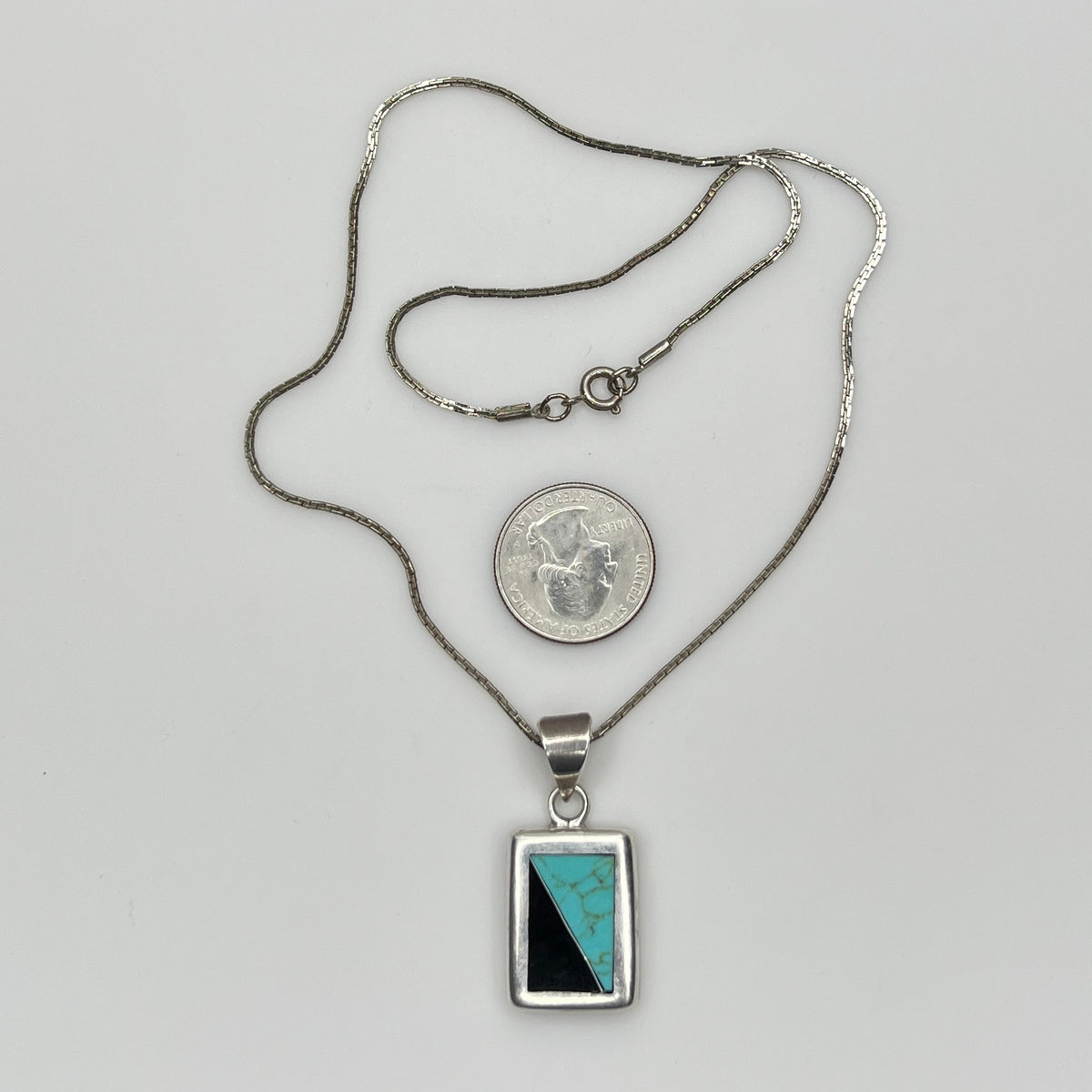 Full view of geometric inlay pendant on chain