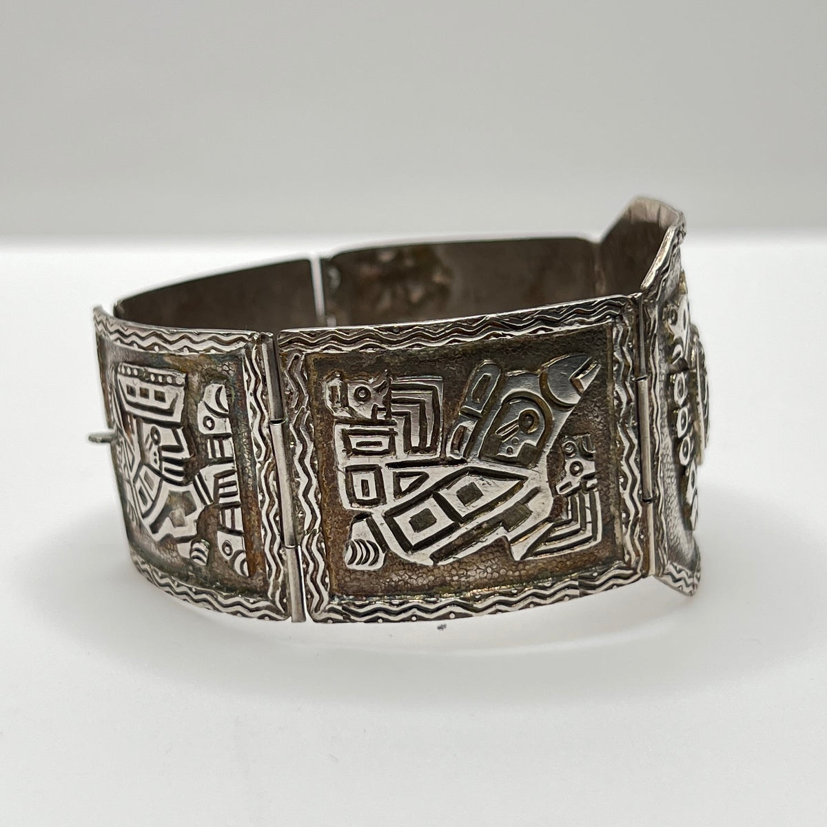 Side view of bracelet panels featuring etched ancient warrior and animal symbols