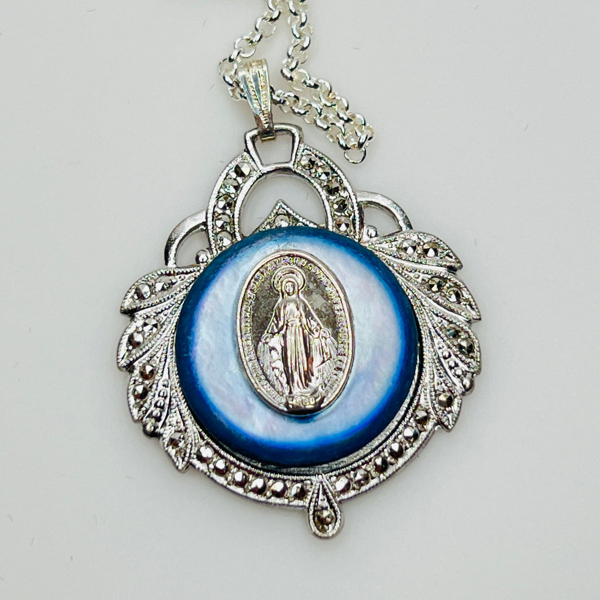Close-up of marcasite Virgin Mary pendant with mother of pearl center