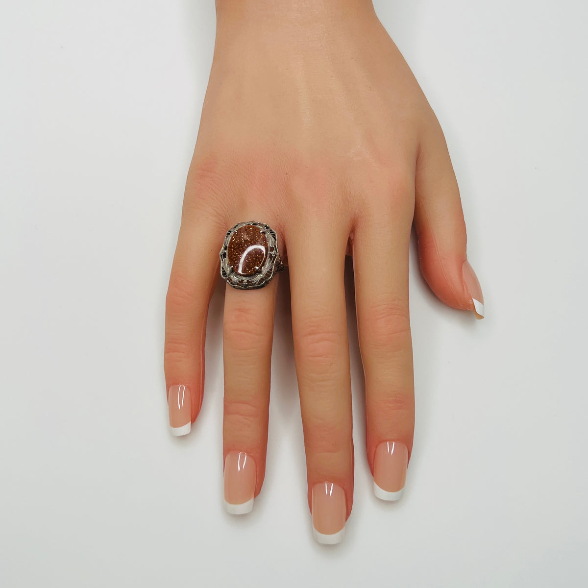 Vintage sterling silver ring with glittering goldstone cabochon and filigree setting