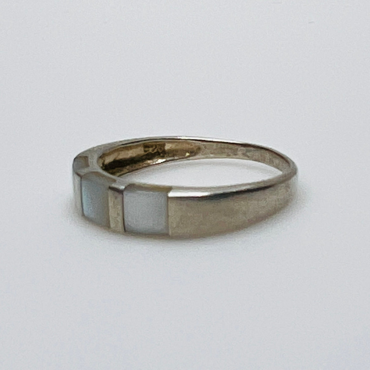 Close-up of iridescent inlay and 925 stamp on inner band