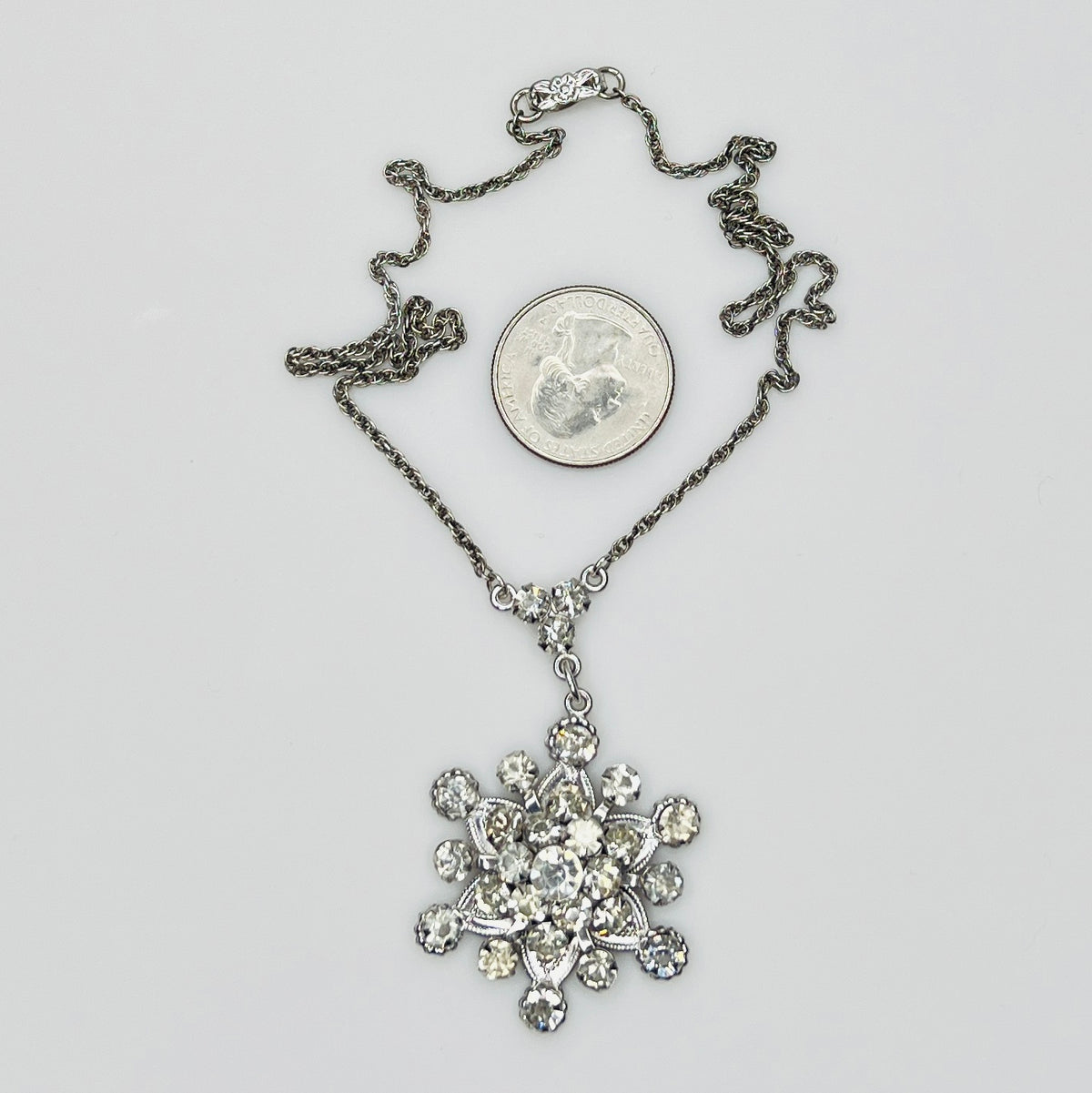 Close-up of clear rhinestone floral pendant in sterling silver setting
