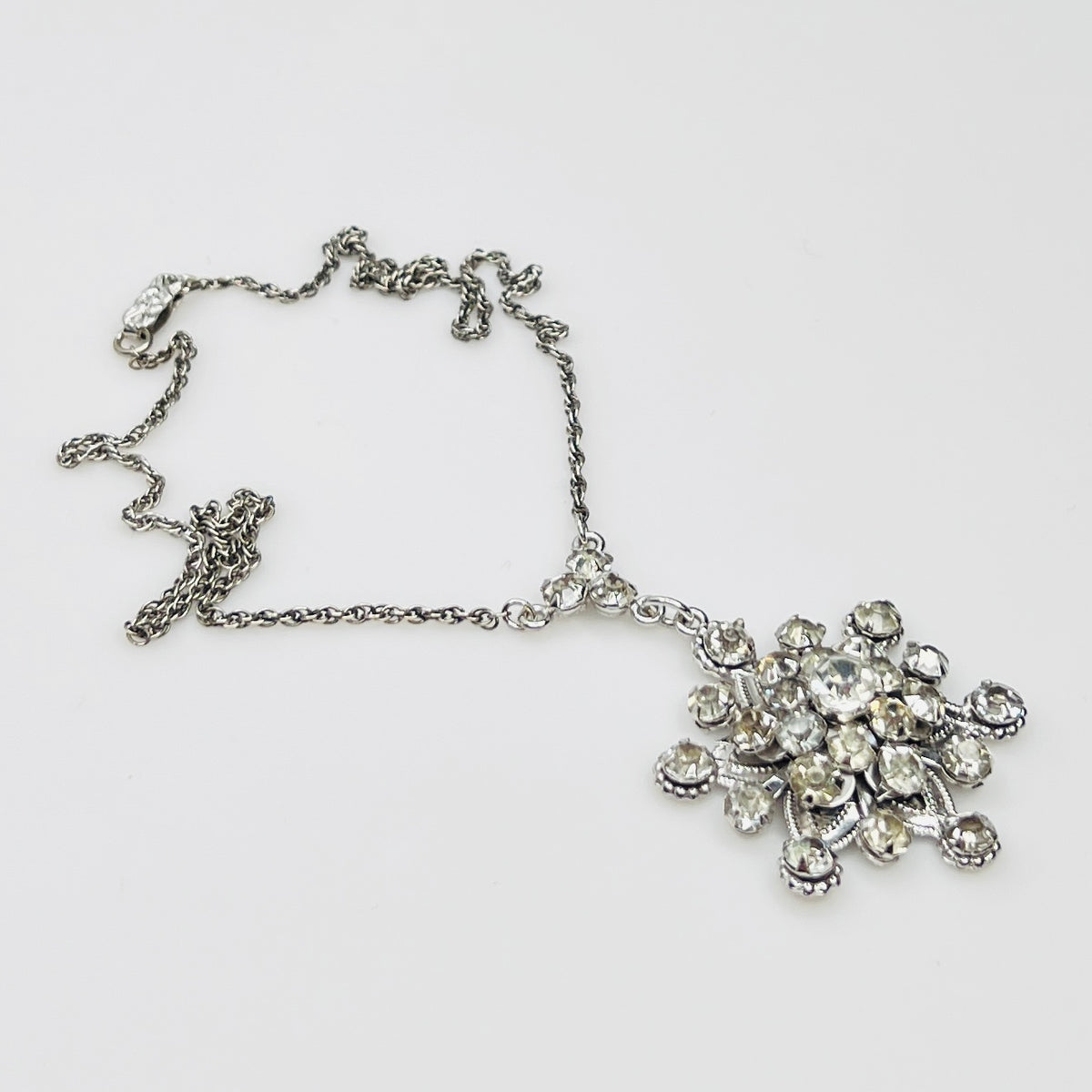 Close-up of clear rhinestone floral pendant in sterling silver setting