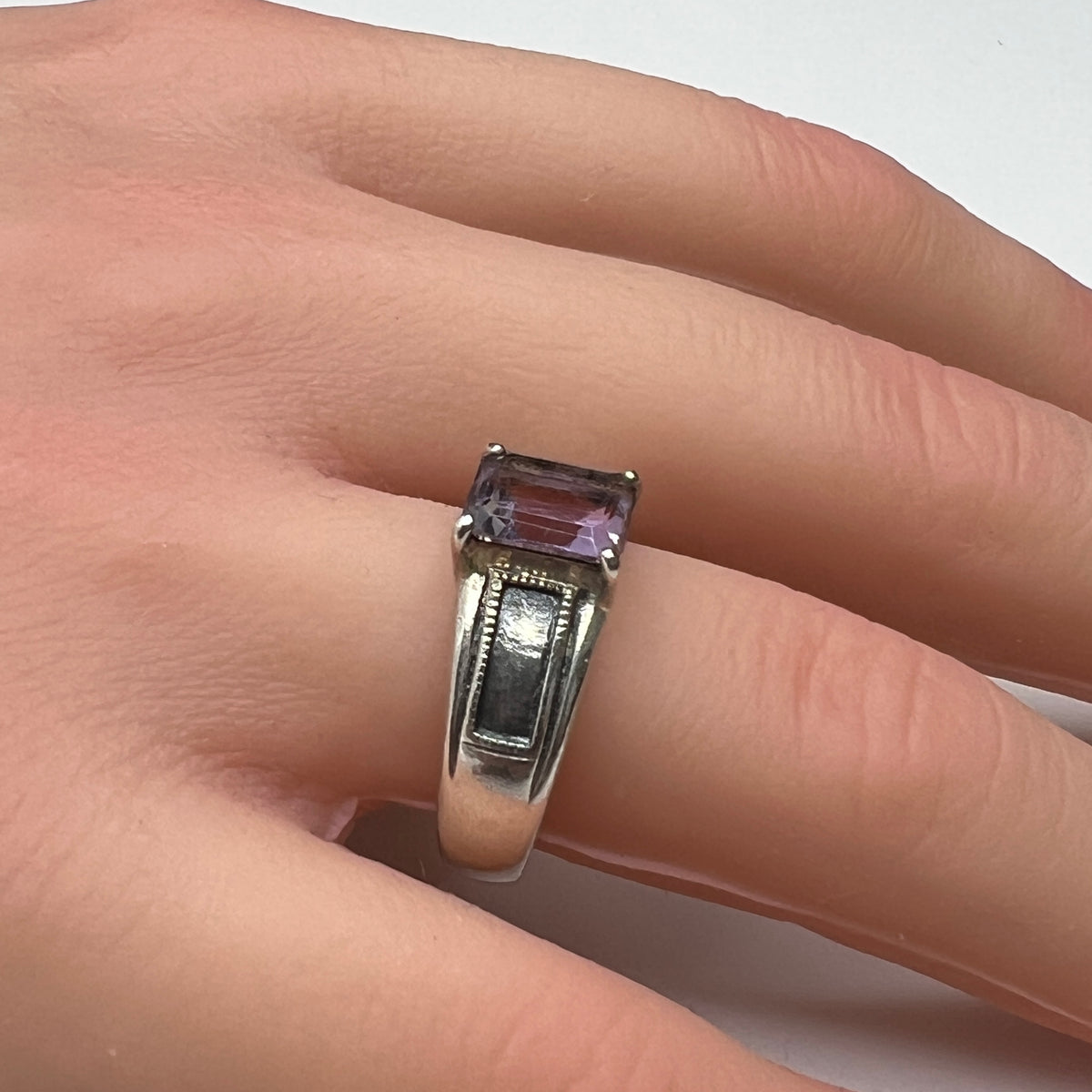 Sterling silver ring with rectangular lavender spinel worn on hand