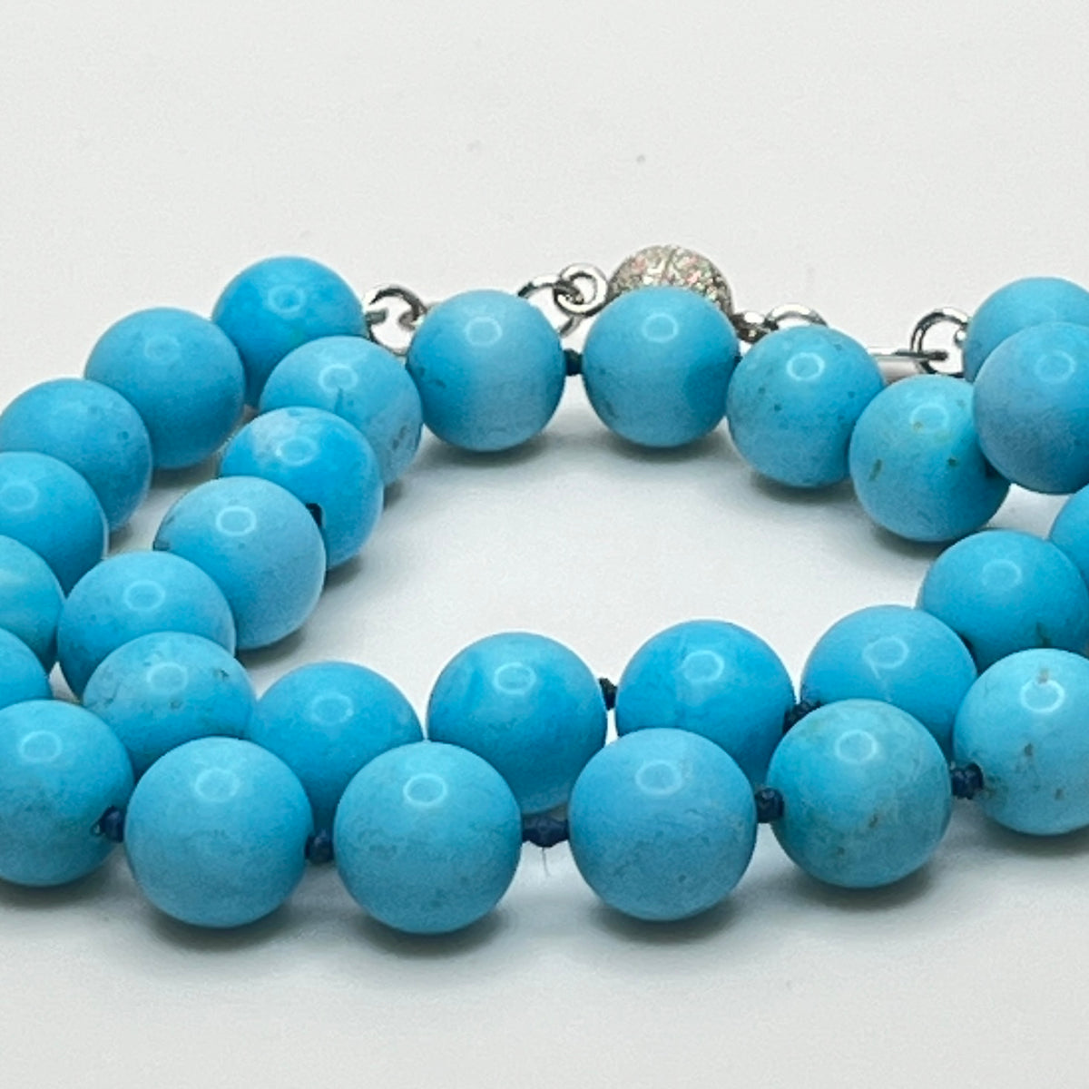 Close-up of turquoise beads with sterling magnetic clasp, laid flat