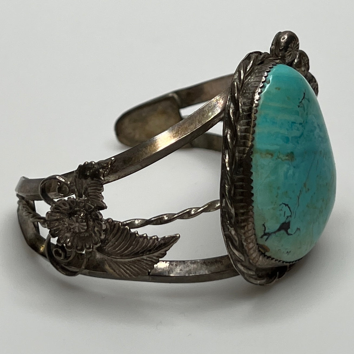 Side view of handcrafted sterling cuff with twisted wire and turquoise cabochon