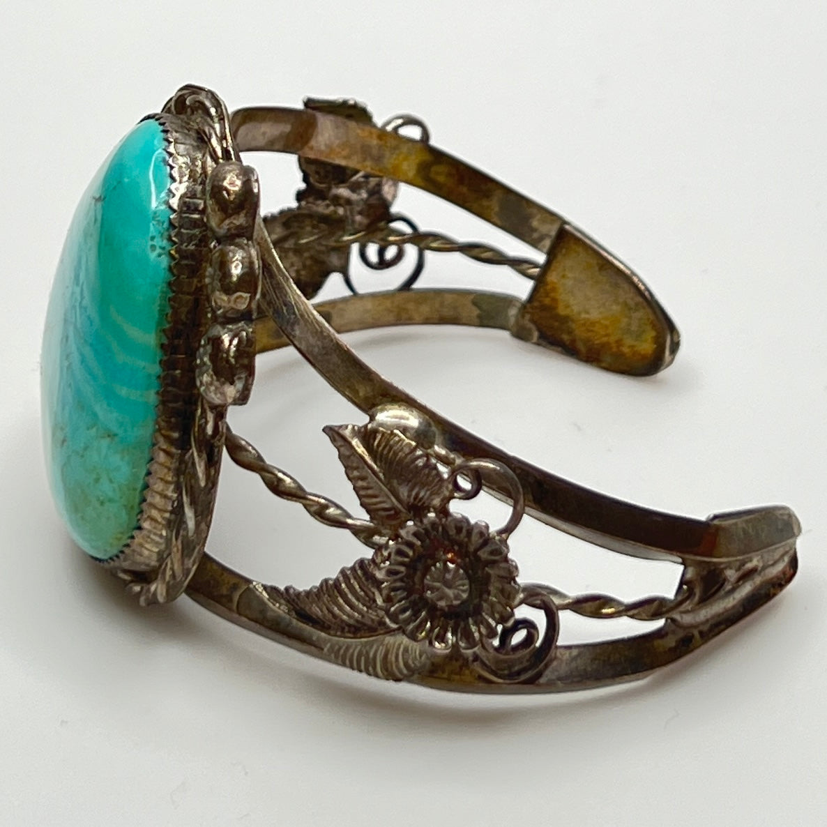 Side view of handcrafted sterling cuff with twisted wire and turquoise cabochon