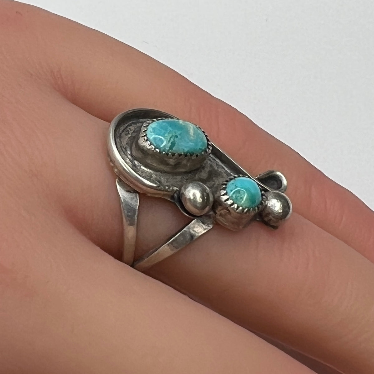 Handmade sterling silver ring with turquoise cabochons on model’s hand