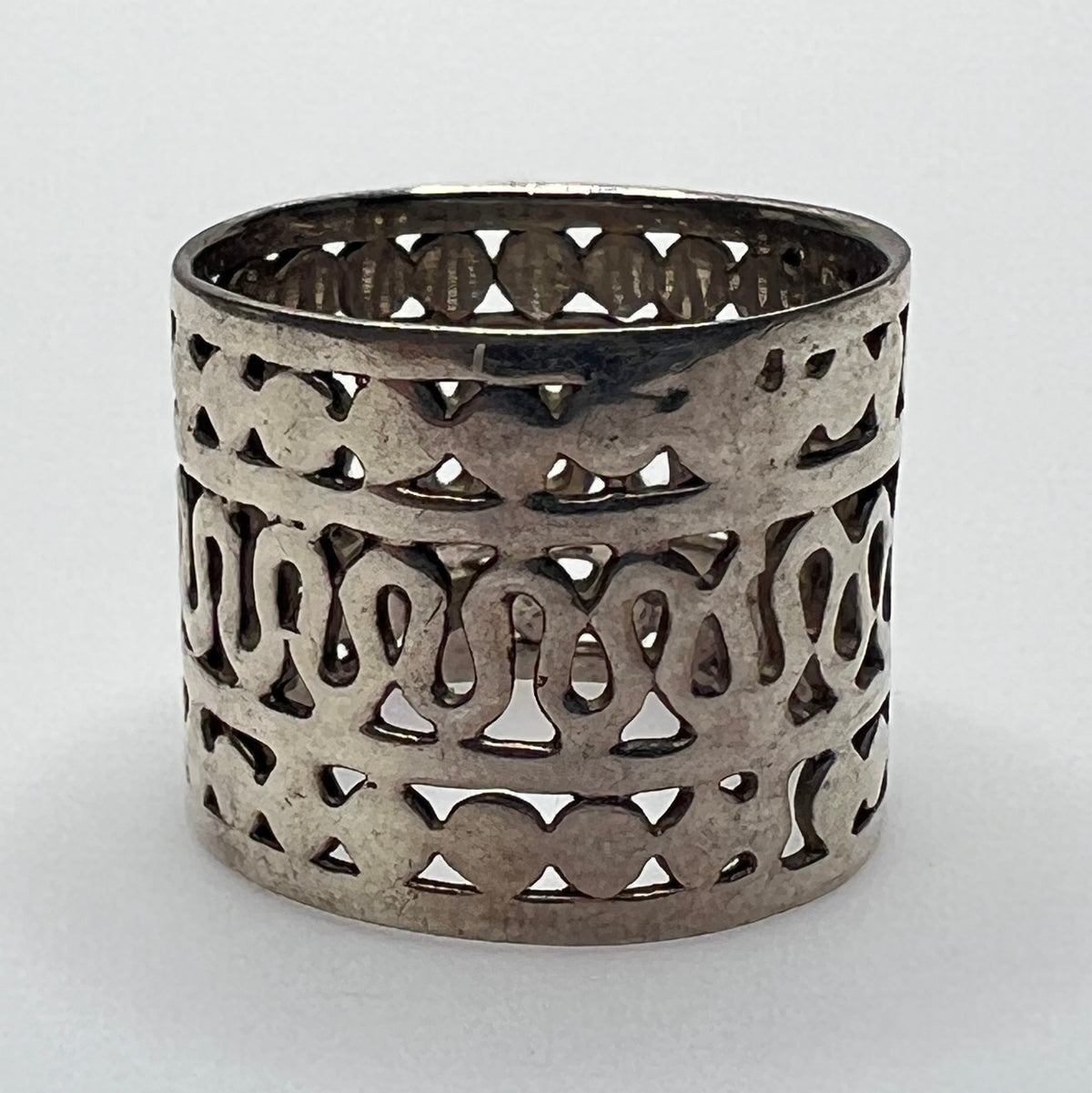 Close-up of openwork silver ring with swirling and geometric pattern