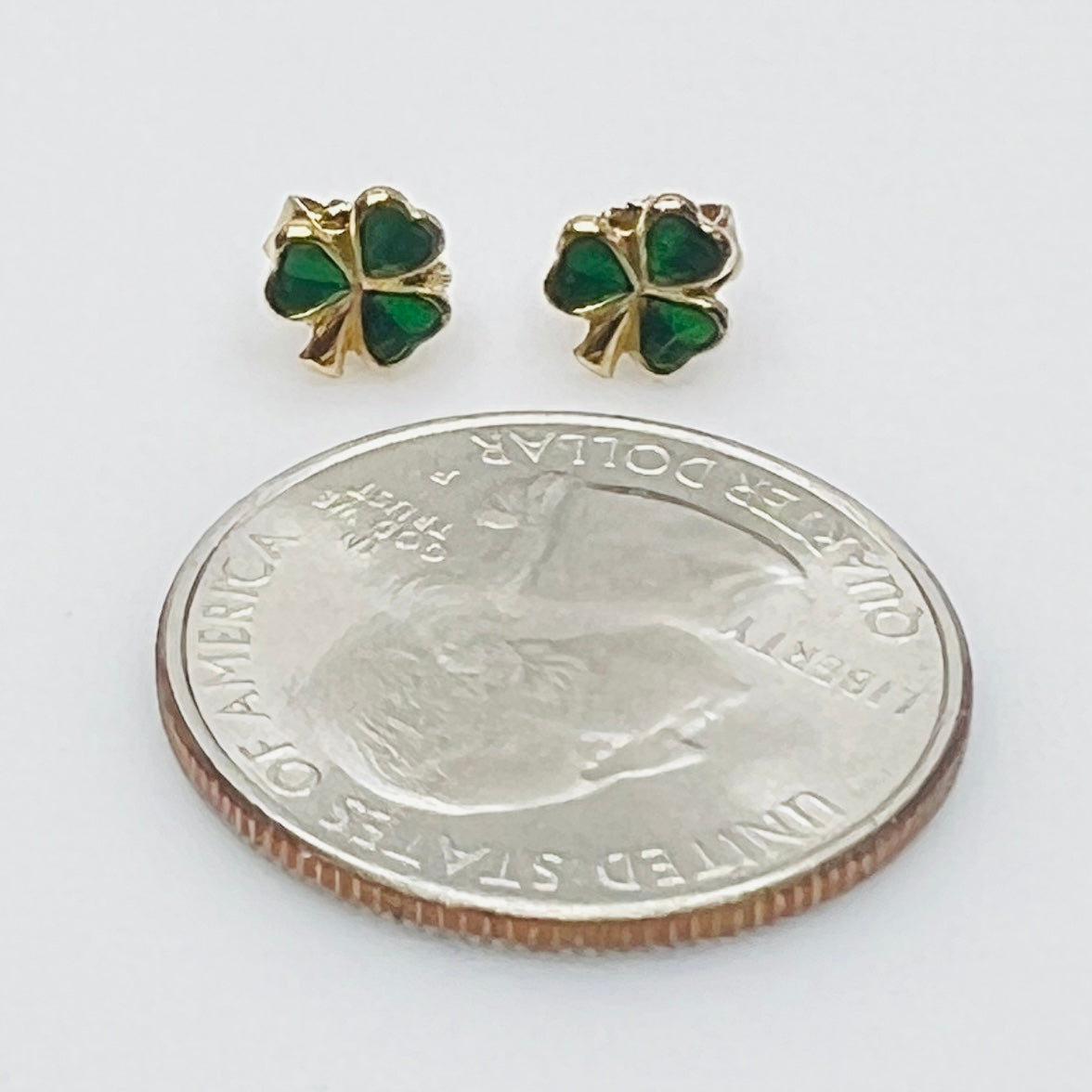 Tiny 14K gold shamrock stud earrings with green enamel cloverleaf design