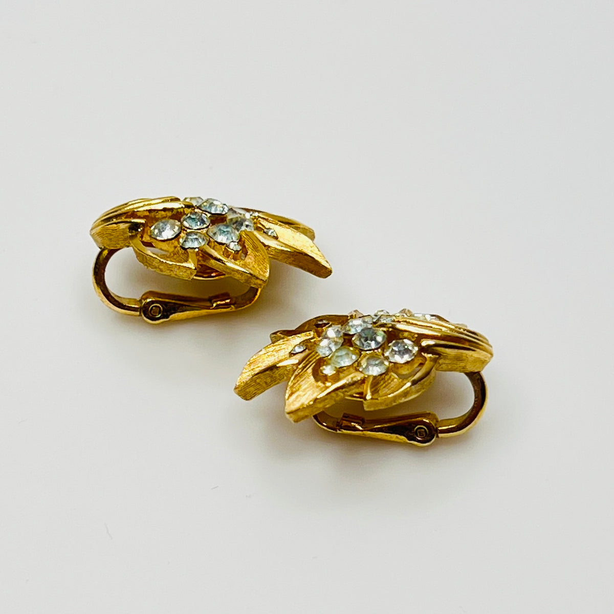 Trifari gold-tone floral clip-on earrings with rhinestone centers