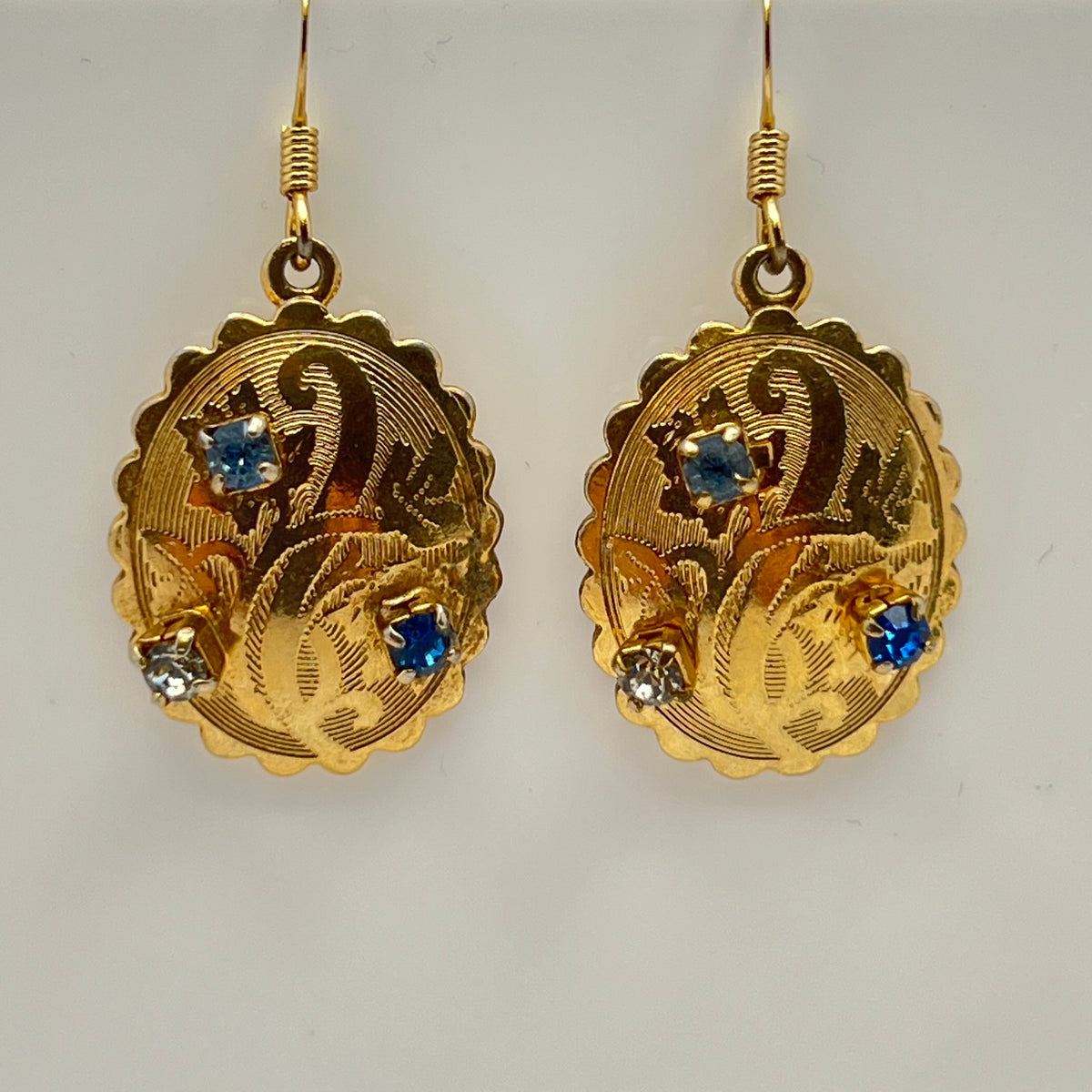 Gold-tone vintage dangle earrings with blue and clear rhinestones, ornate etched design