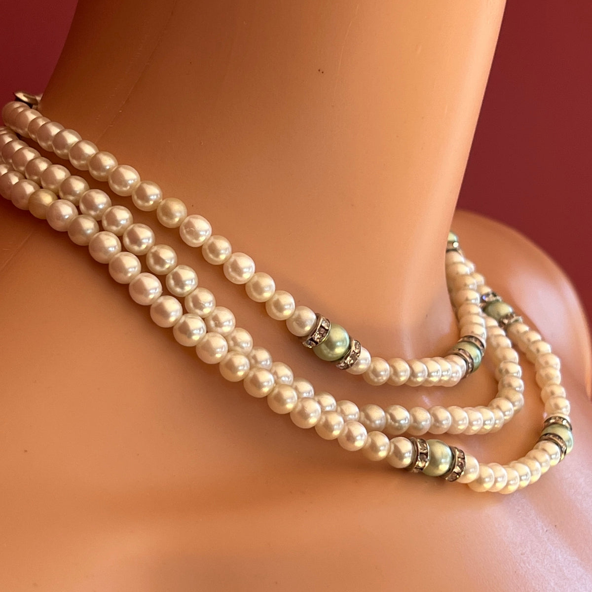 Three-strand faux pearl necklace and bracelet set with sage green pearls and rhinestone spacers.