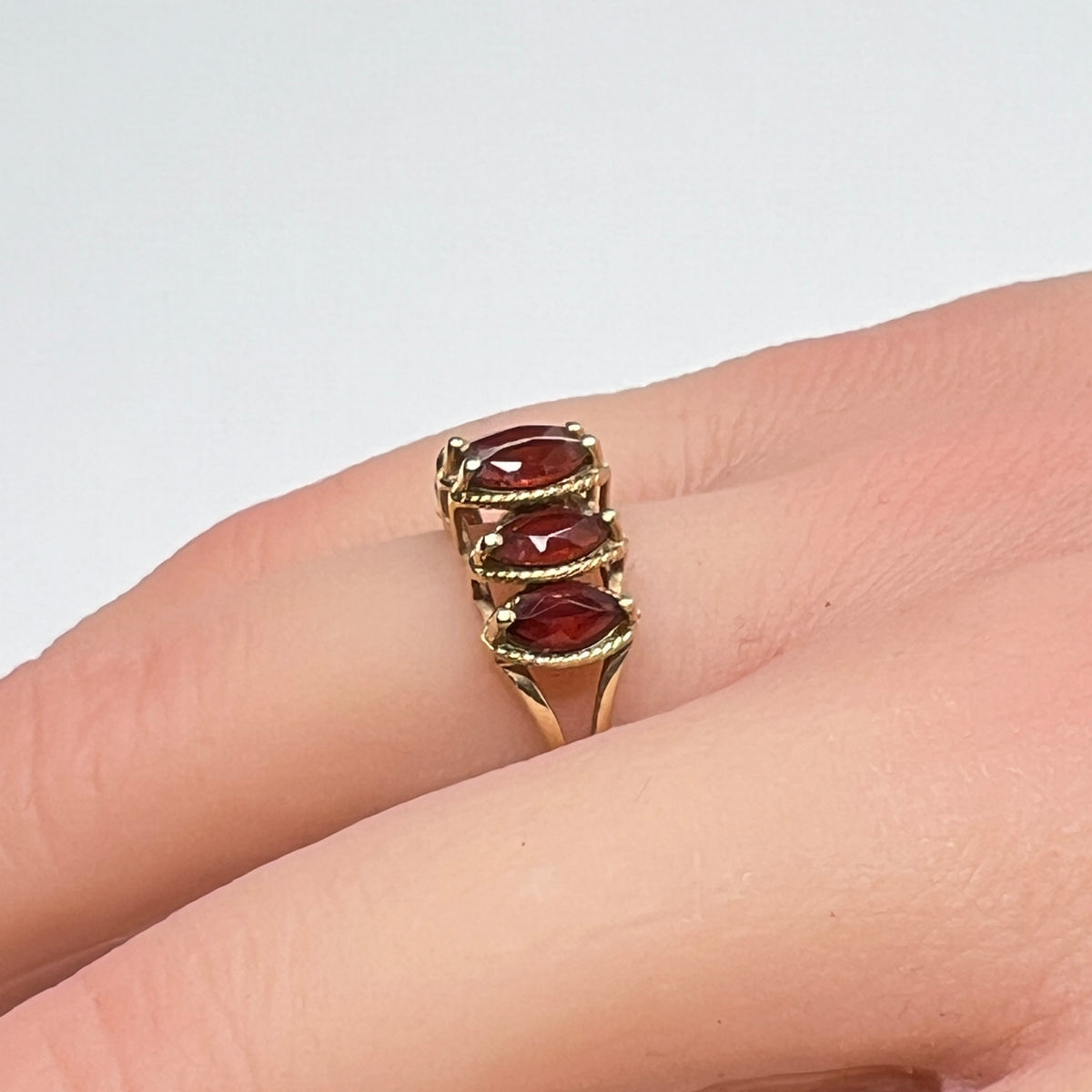 Vintage 10K gold ring with five marquise garnets on model’s hand