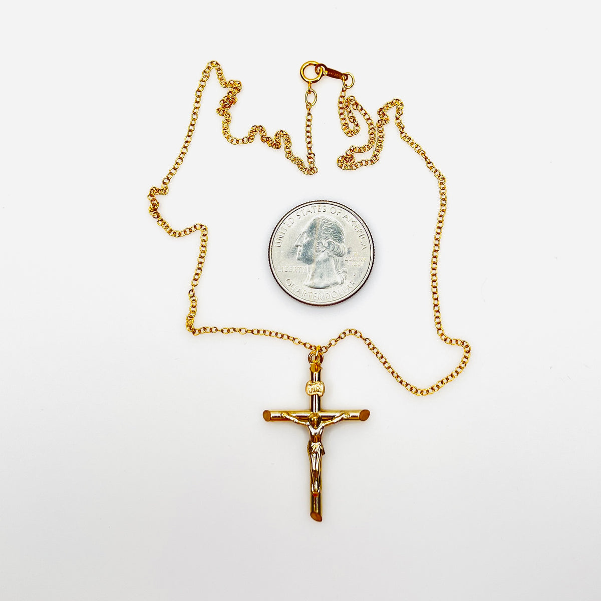 Vintage 14K gold filled crucifix necklace with quarter for size comparison.