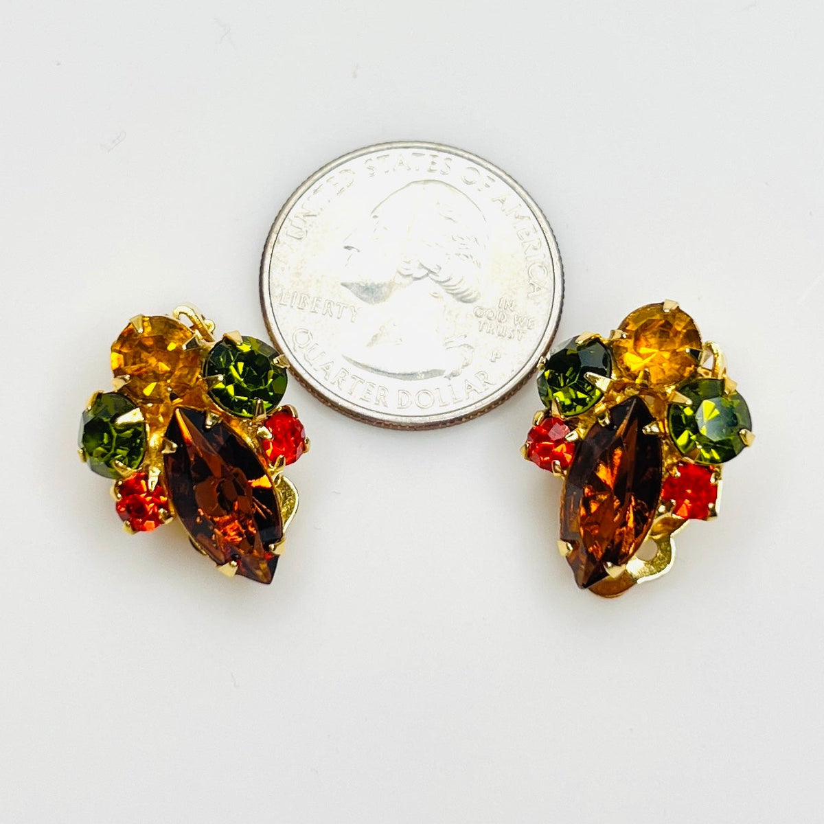 Colorful vintage rhinestone clip earrings shown with quarter for size.