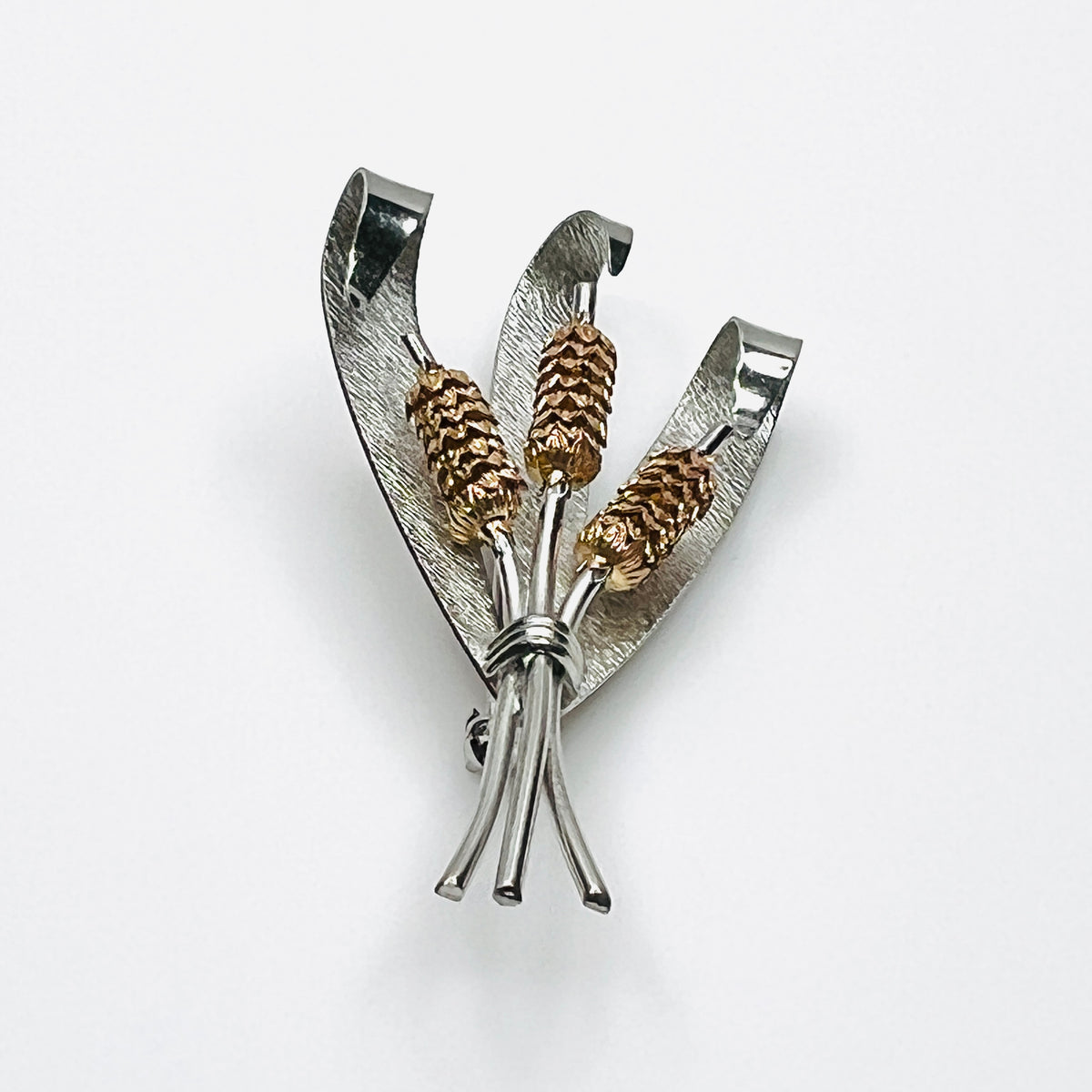 Side view of vintage two-tone cattail brooch showing dimensional metal construction