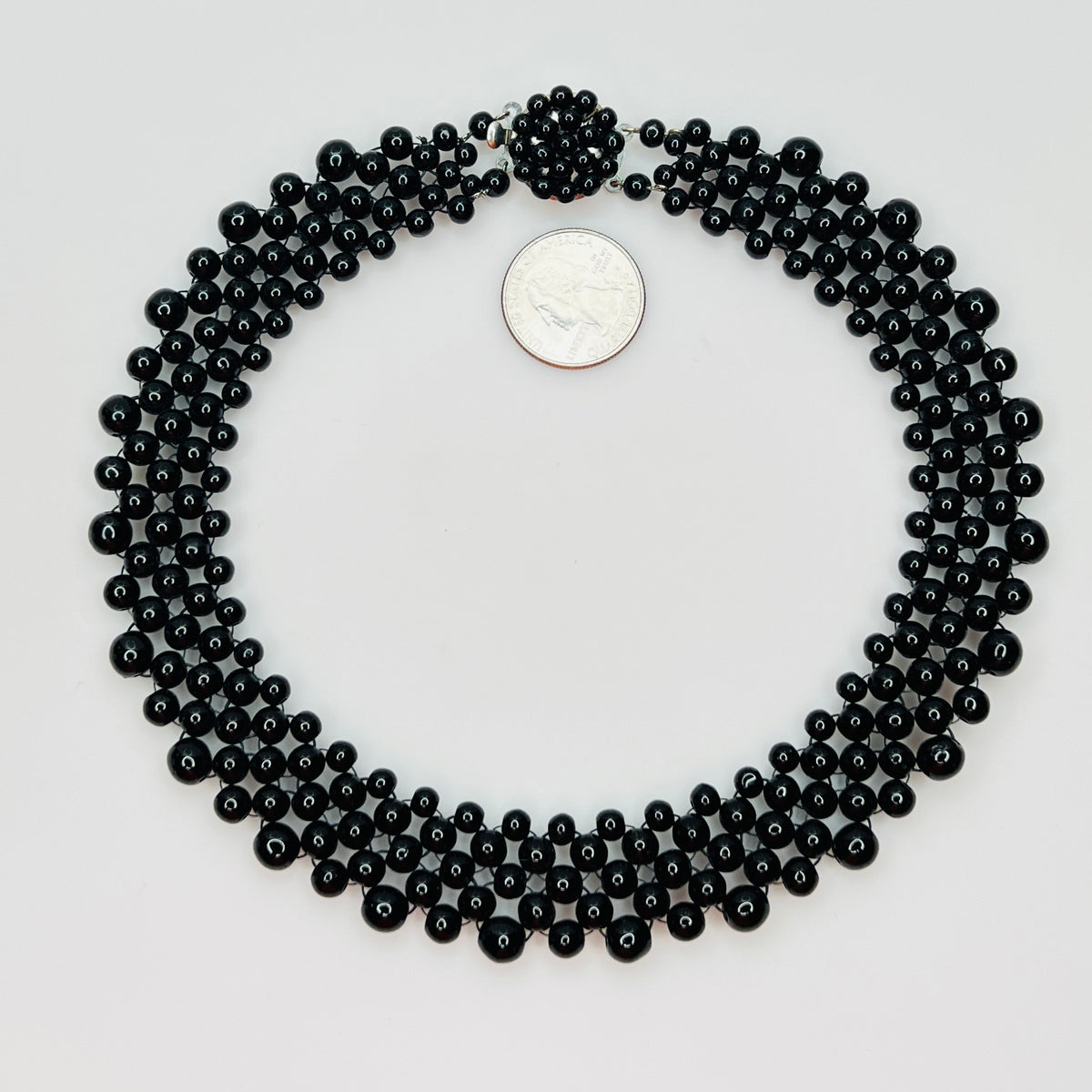 Top view of multi strand black beaded collar necklace