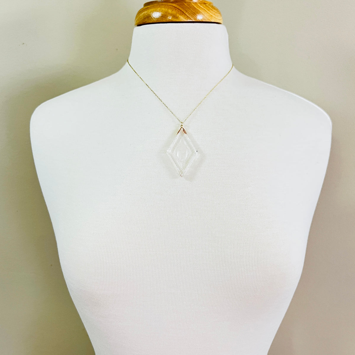 Necklace worn on mannequin showing large clear intaglio pendant