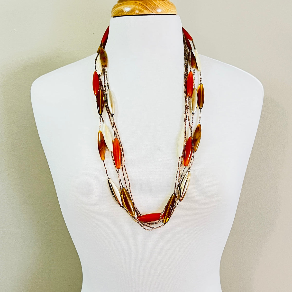 Long 1970s lucite necklace displayed on mannequin with layered strands