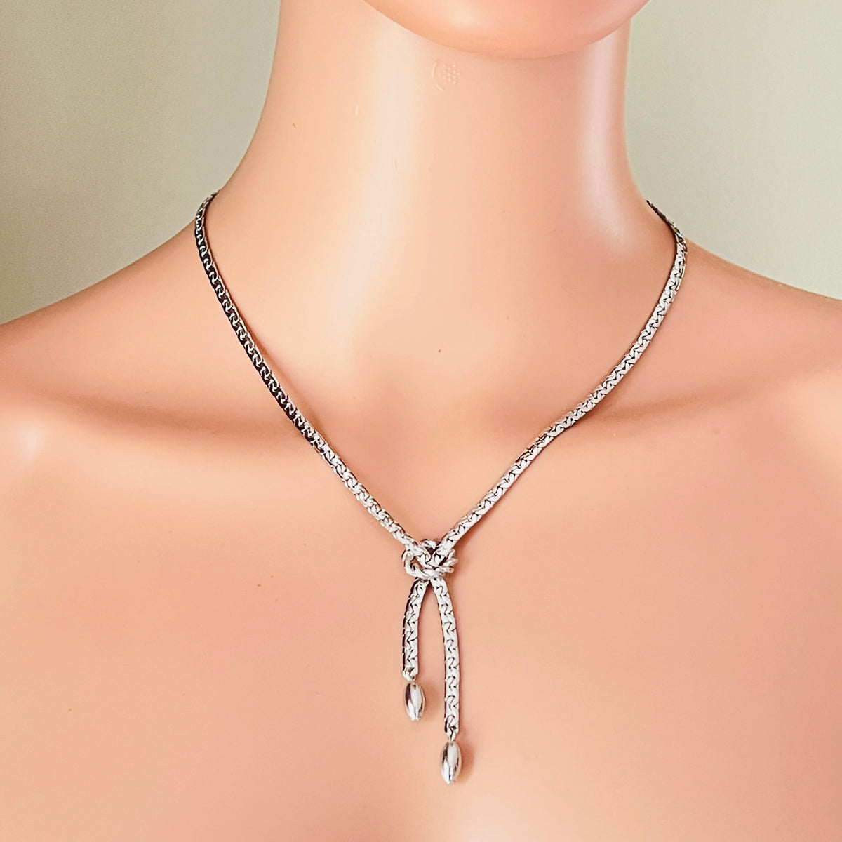 Silver textured Y necklace worn on mannequin with knot detail