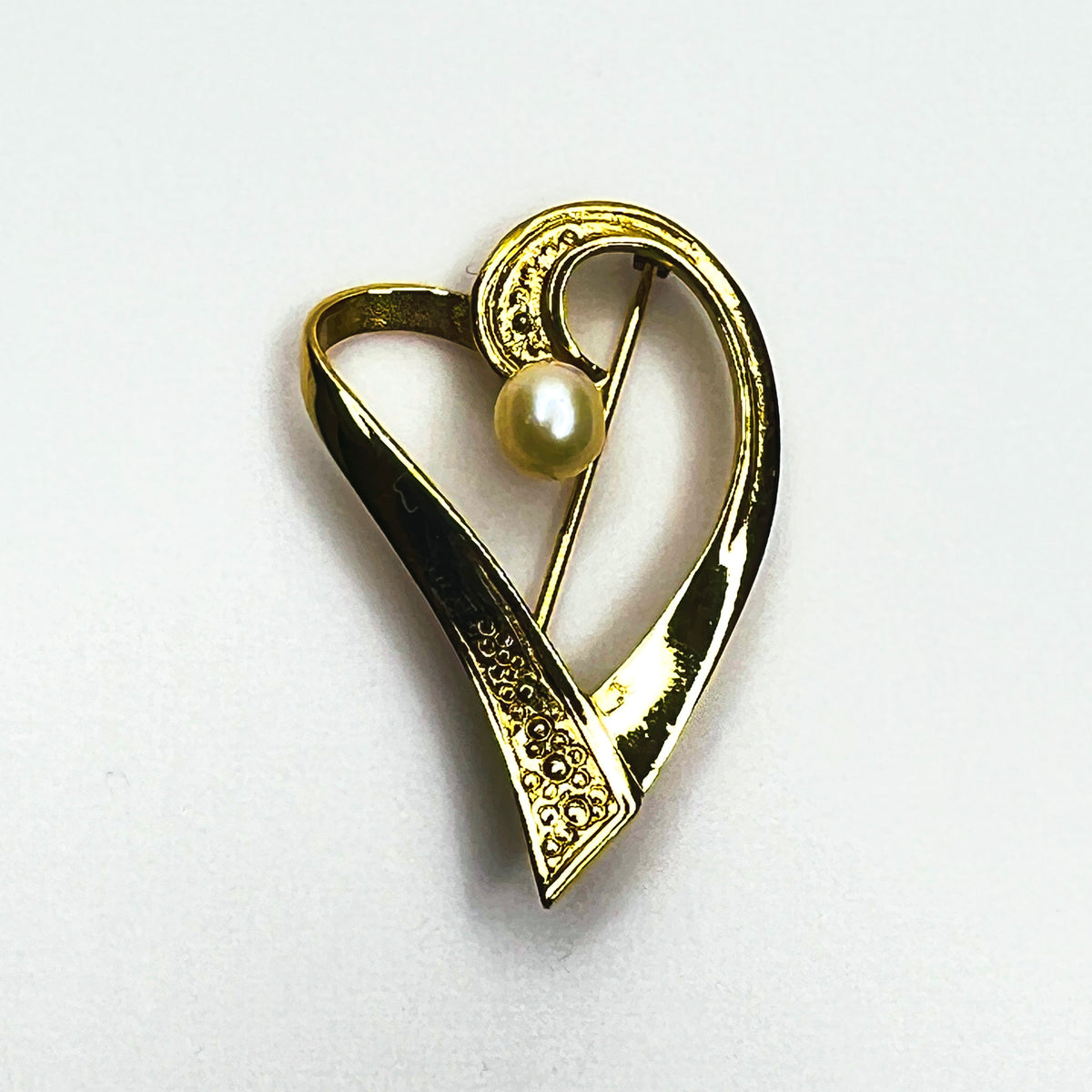 Vintage 1970s sterling silver vermeil heart brooch with asymmetrical gold ribbon design, textured accents and genuine cultured pearl.