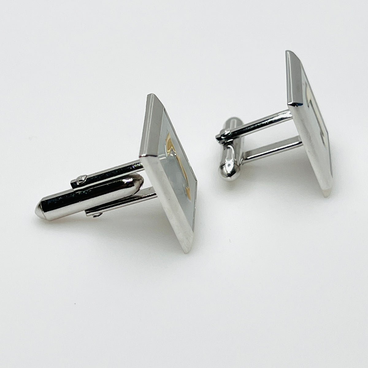 Side view of vintage Swank cufflinks showing silver tone swivel bar closures